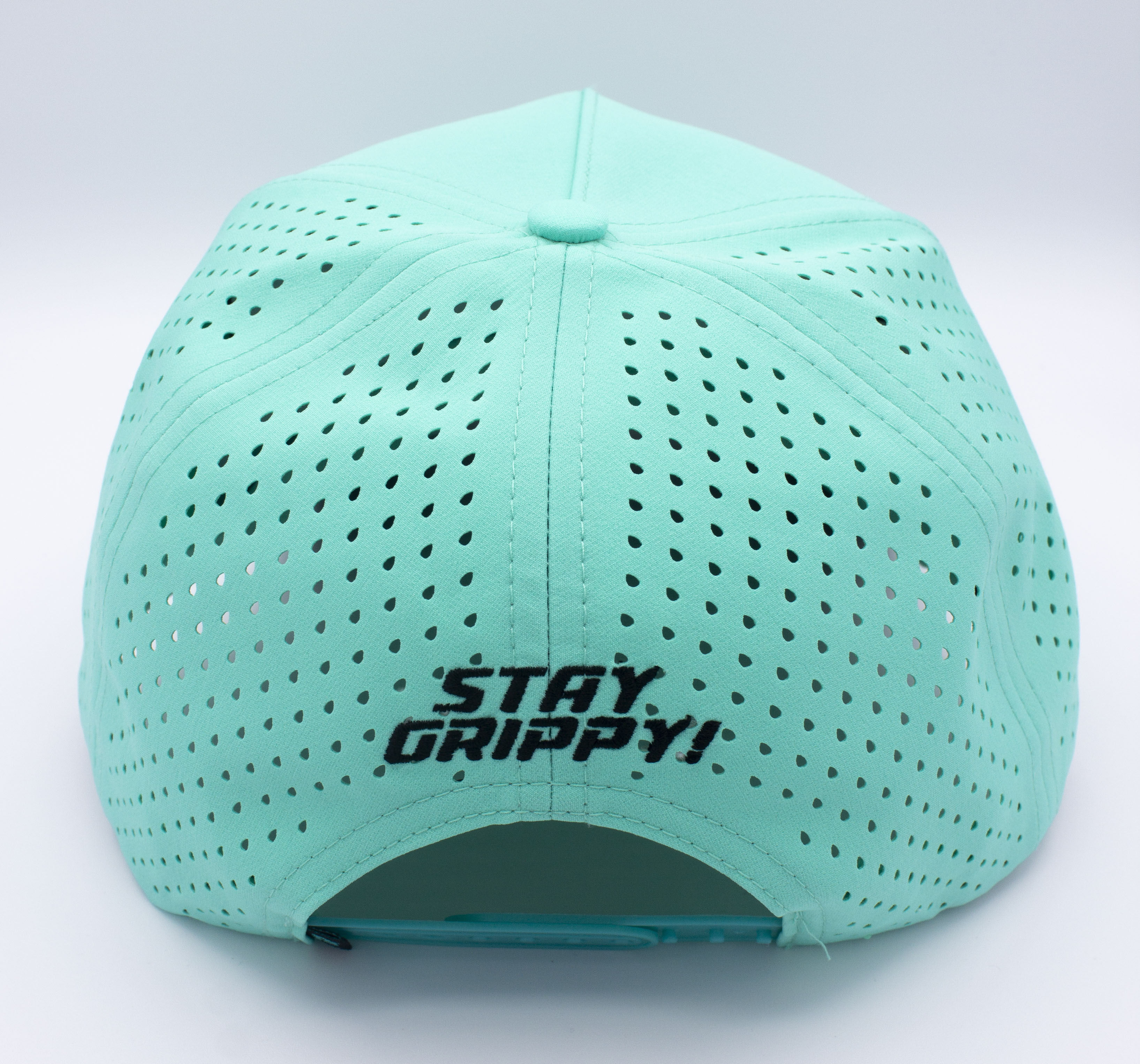 Back of a turquoise baseball cap with air holes and "STAY GRIPPY!" embroidered in black.