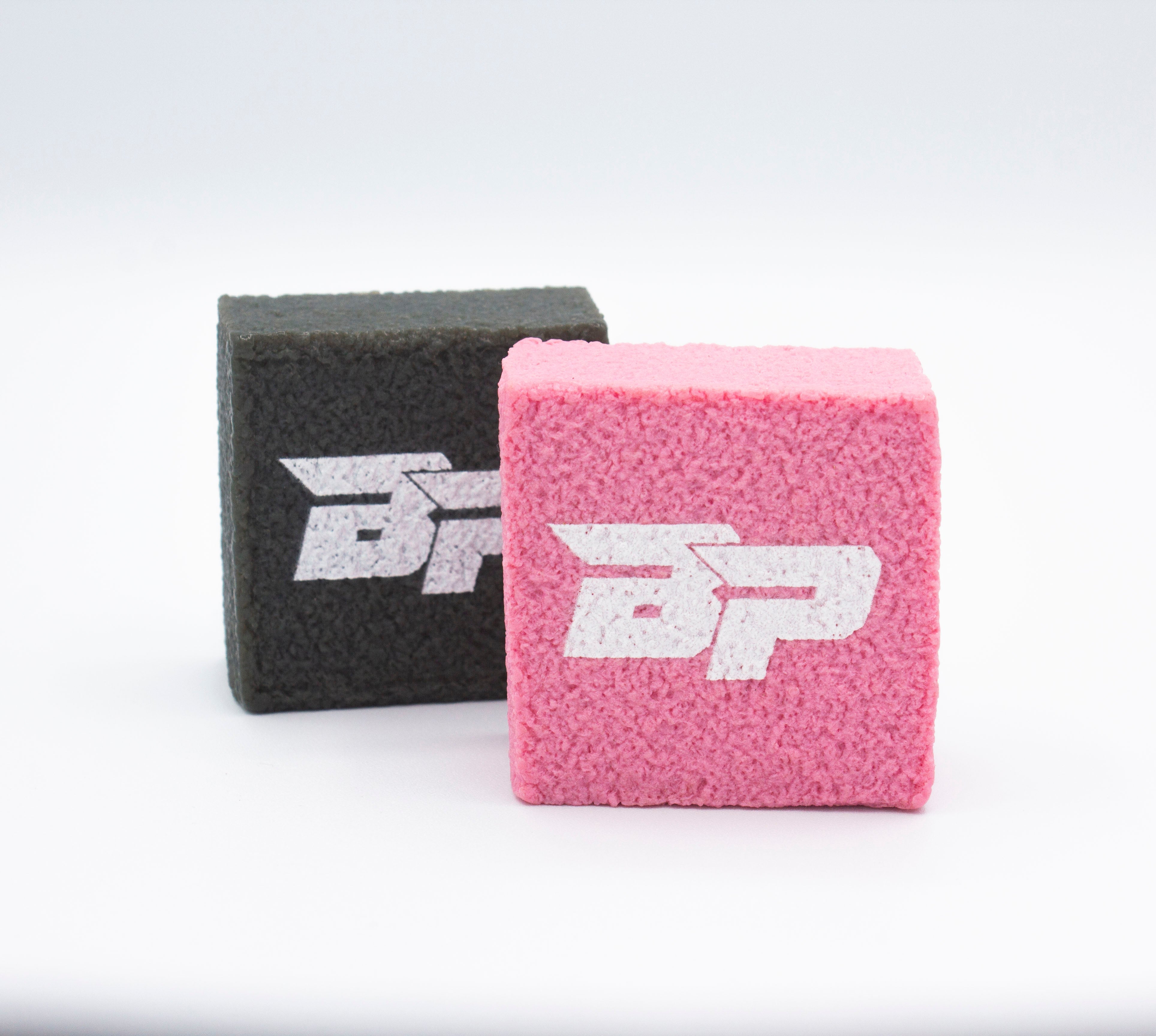 Two fuzzy, cube-shaped wristbands, one gray and one pink, both with a white stylized "BP" logo, on a white background.