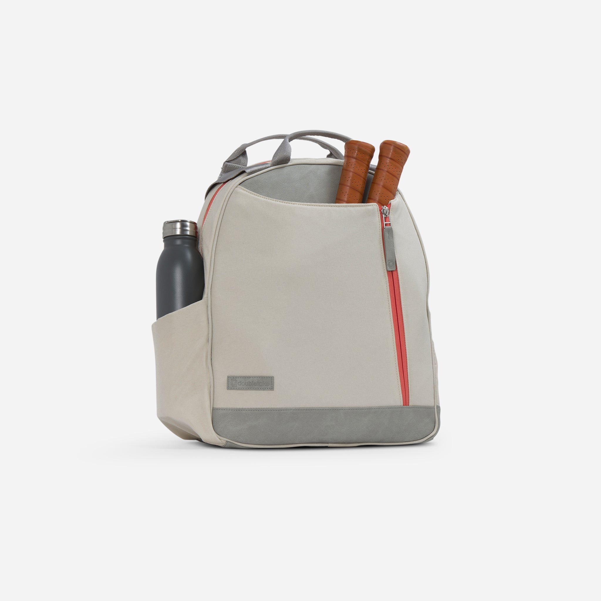 Beige tote bag with water bottle and tennis racquets.