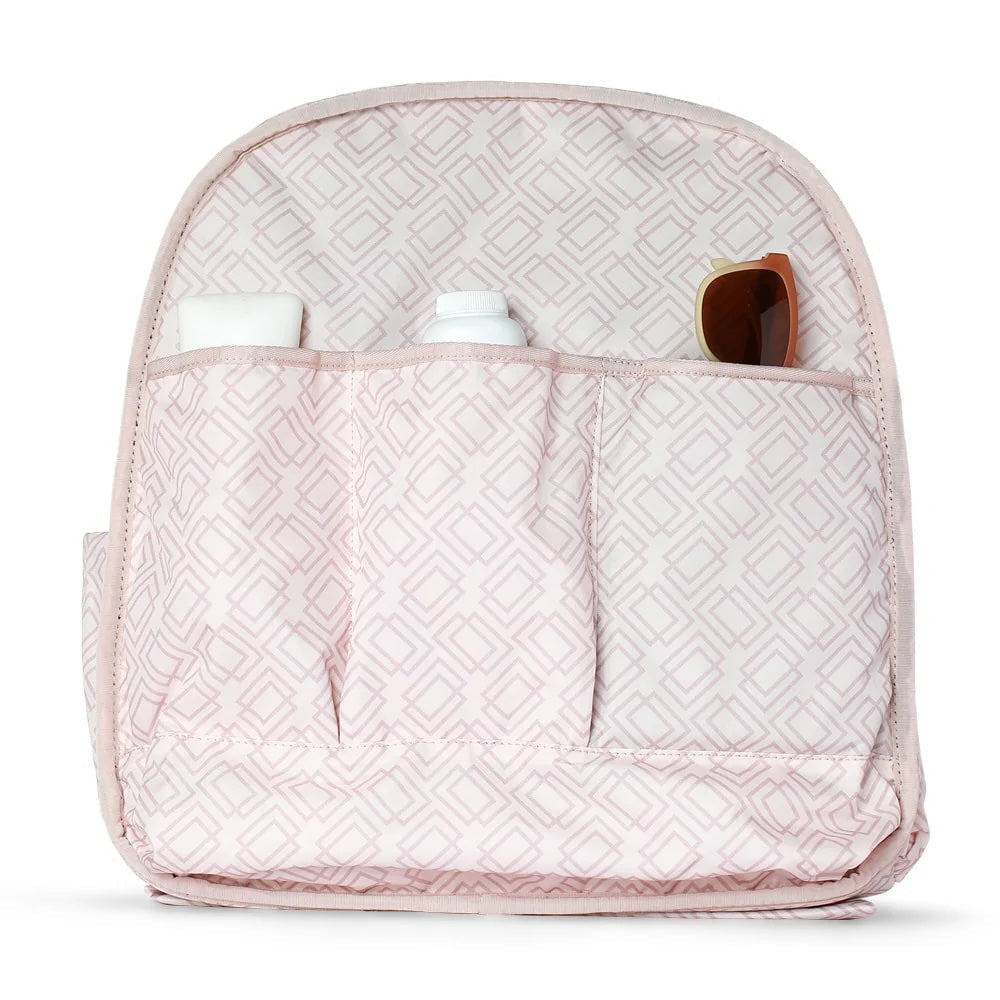 Pink patterned interior of a Tennis Backpack & Tote by Doubletake, showing three organizer pockets holding a white block, a white bottle, and brown sunglasses.