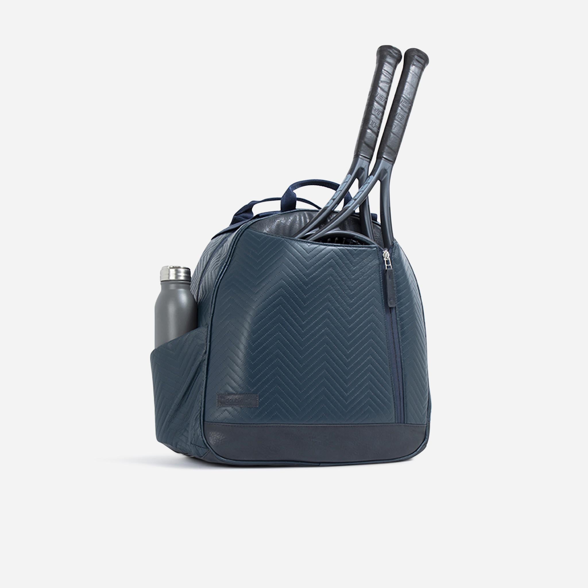 Dark blue tennis backpack and tote by Doubletake, with a chevron pattern, holding two rackets and a gray water bottle.