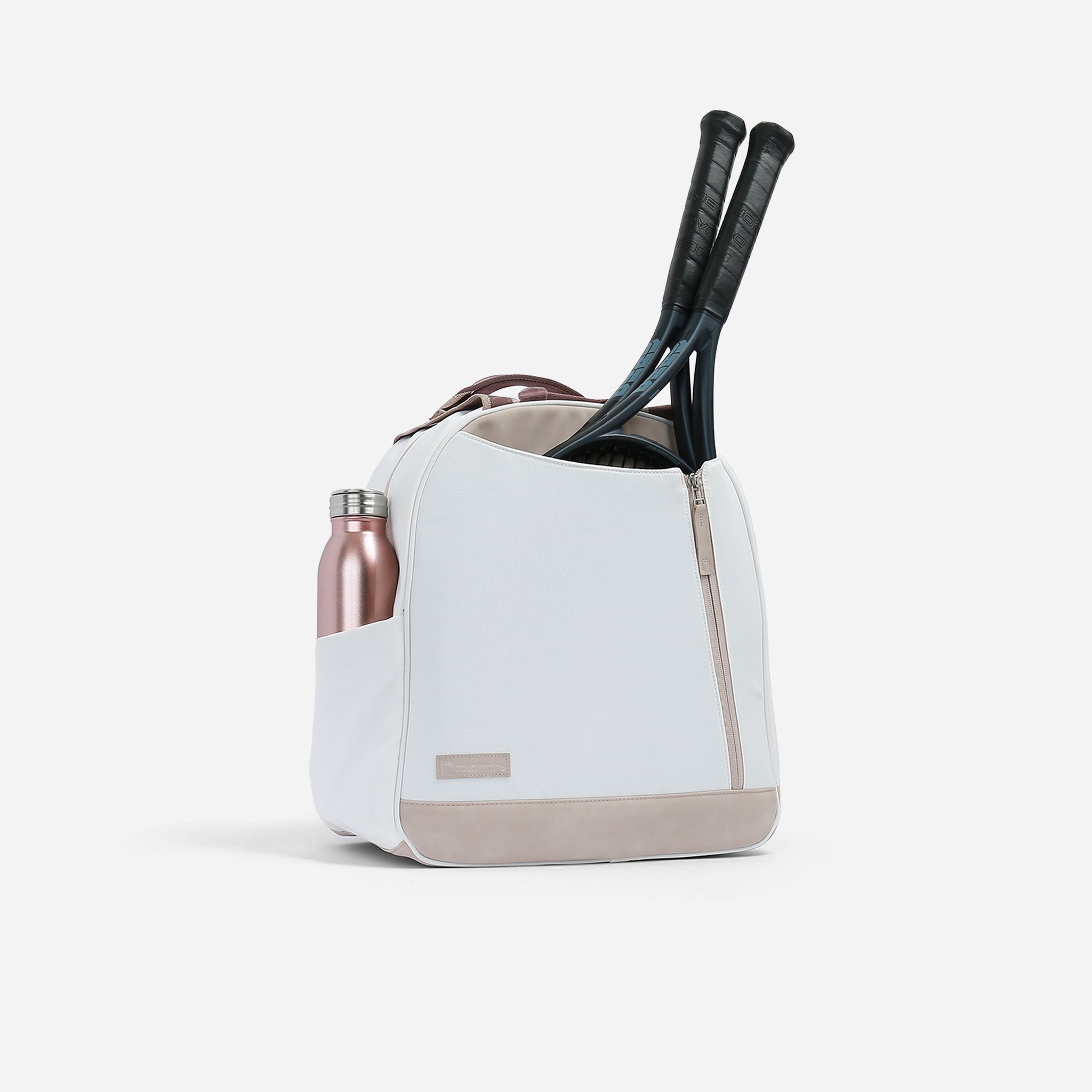 White and tan Tennis Backpack & Tote by Doubletake, featuring a small logo label, two rackets, and a rose gold water bottle.