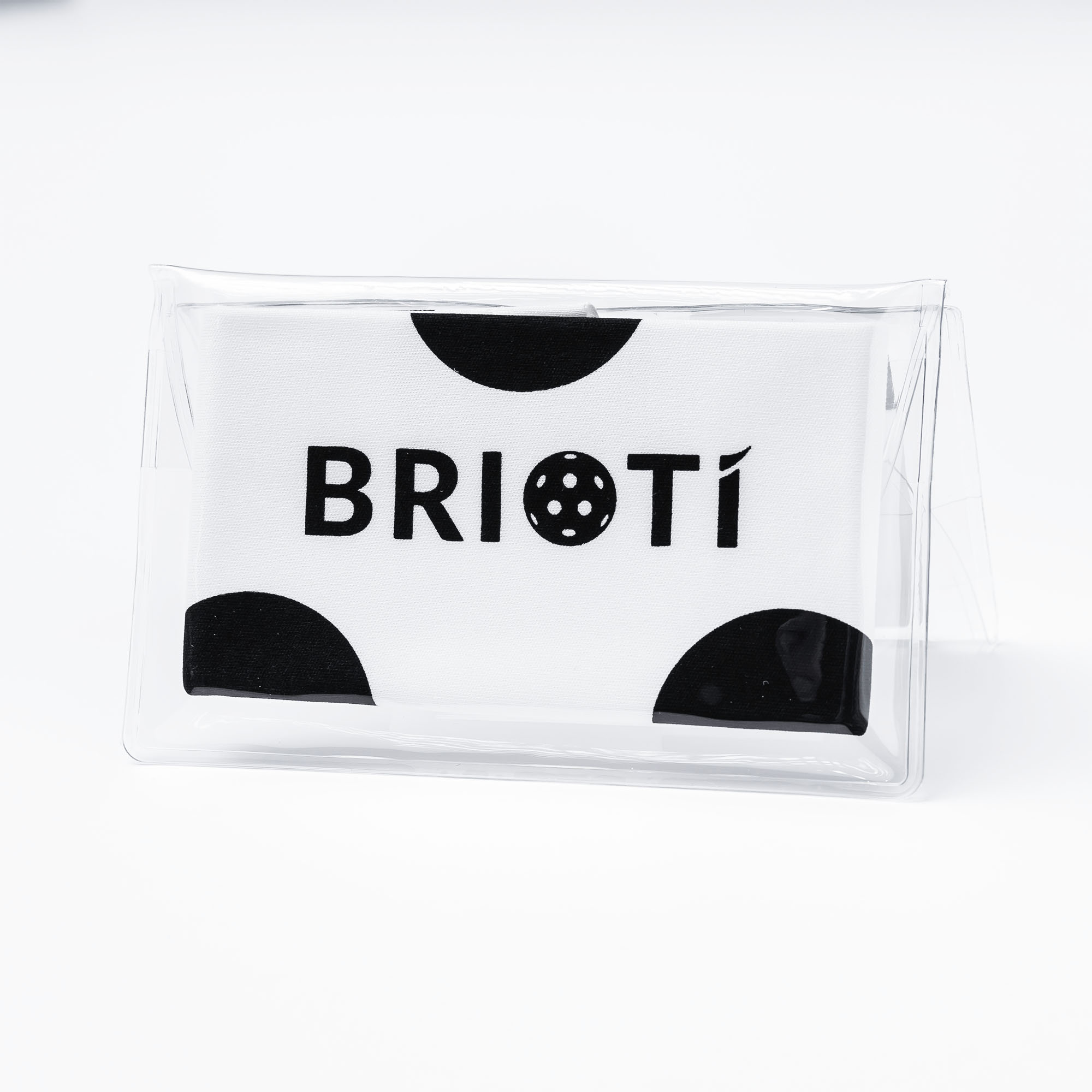 White towel with black polka dots and "BRIOTI" logo in a clear plastic package.

