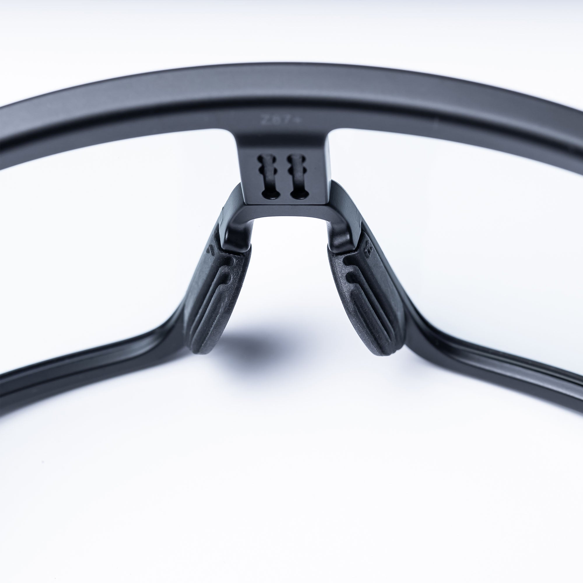 Close-up of black eyewear with clear lenses and textured nose pads.