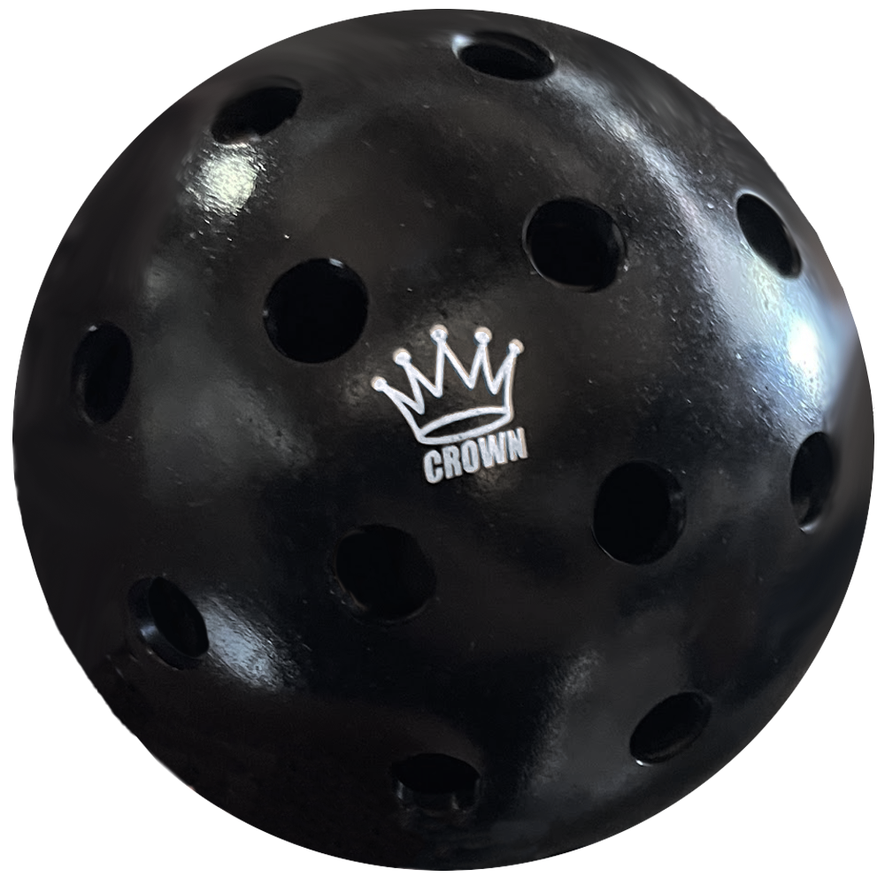 Close-up of a black Wiffle ball with holes and a white "Crown" logo.
