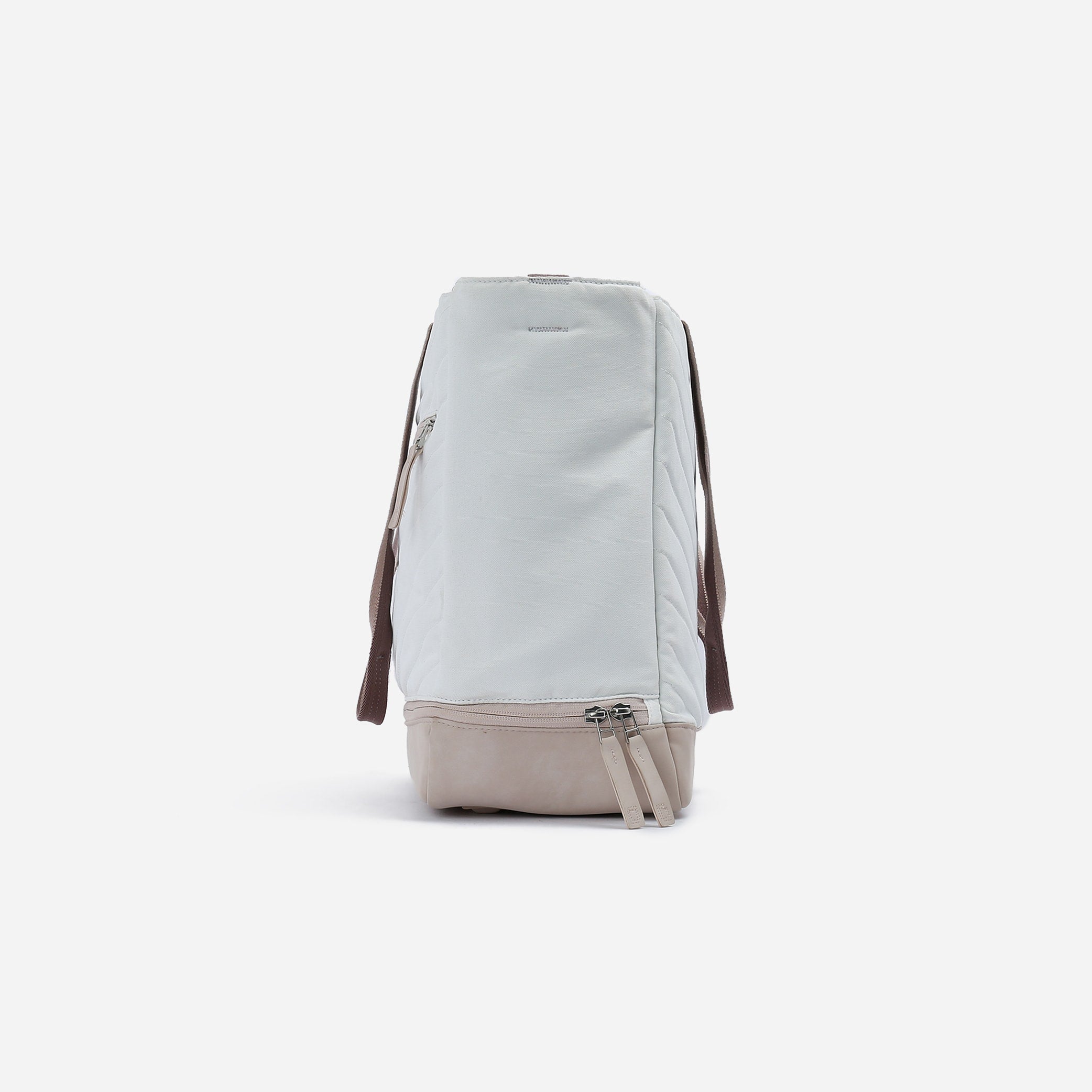 Light grey and beige Tennis Tote by Doubletake, seen from the side with quilted panels and multiple zipper compartments.