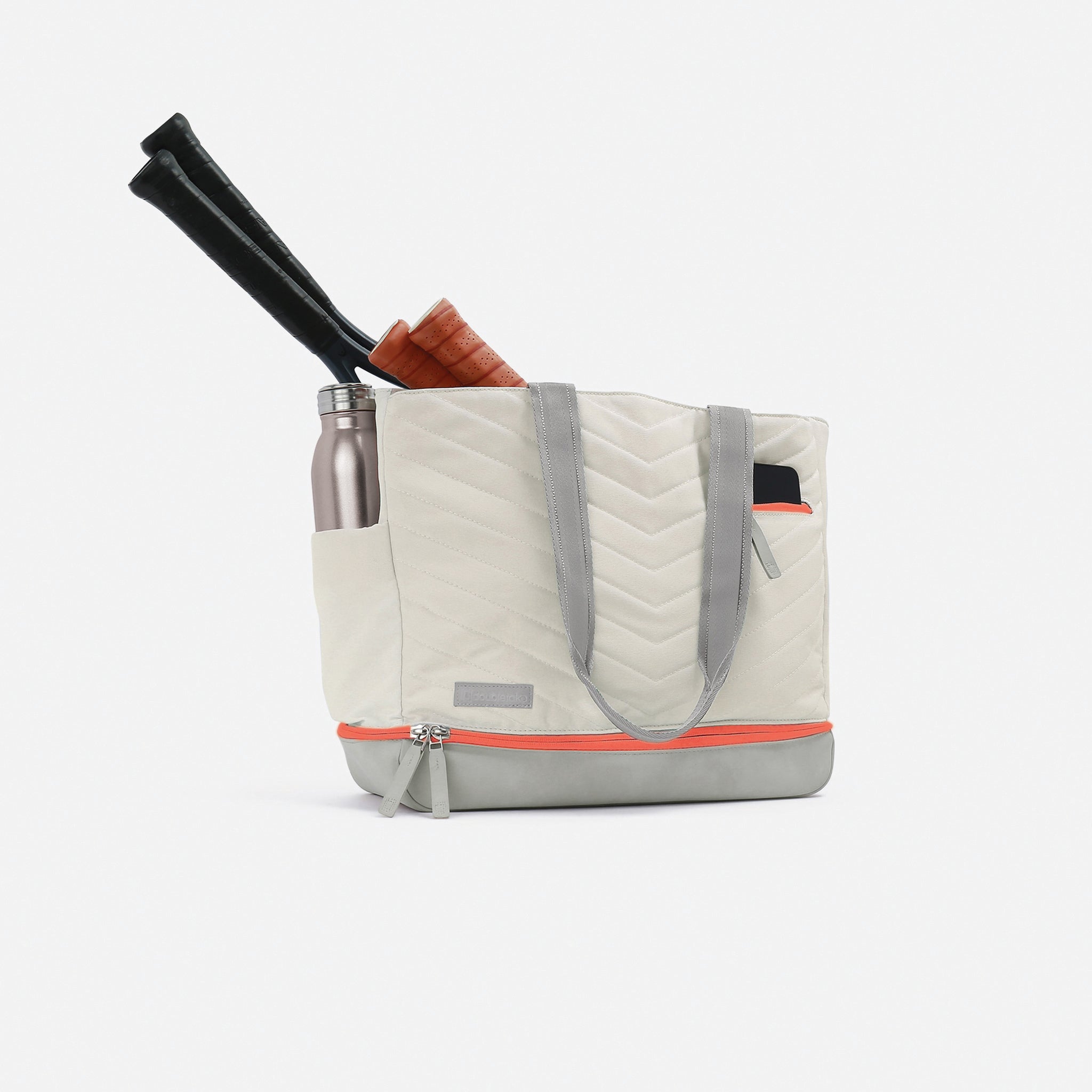 Quilted tote bag with tennis rackets and a water bottle.
