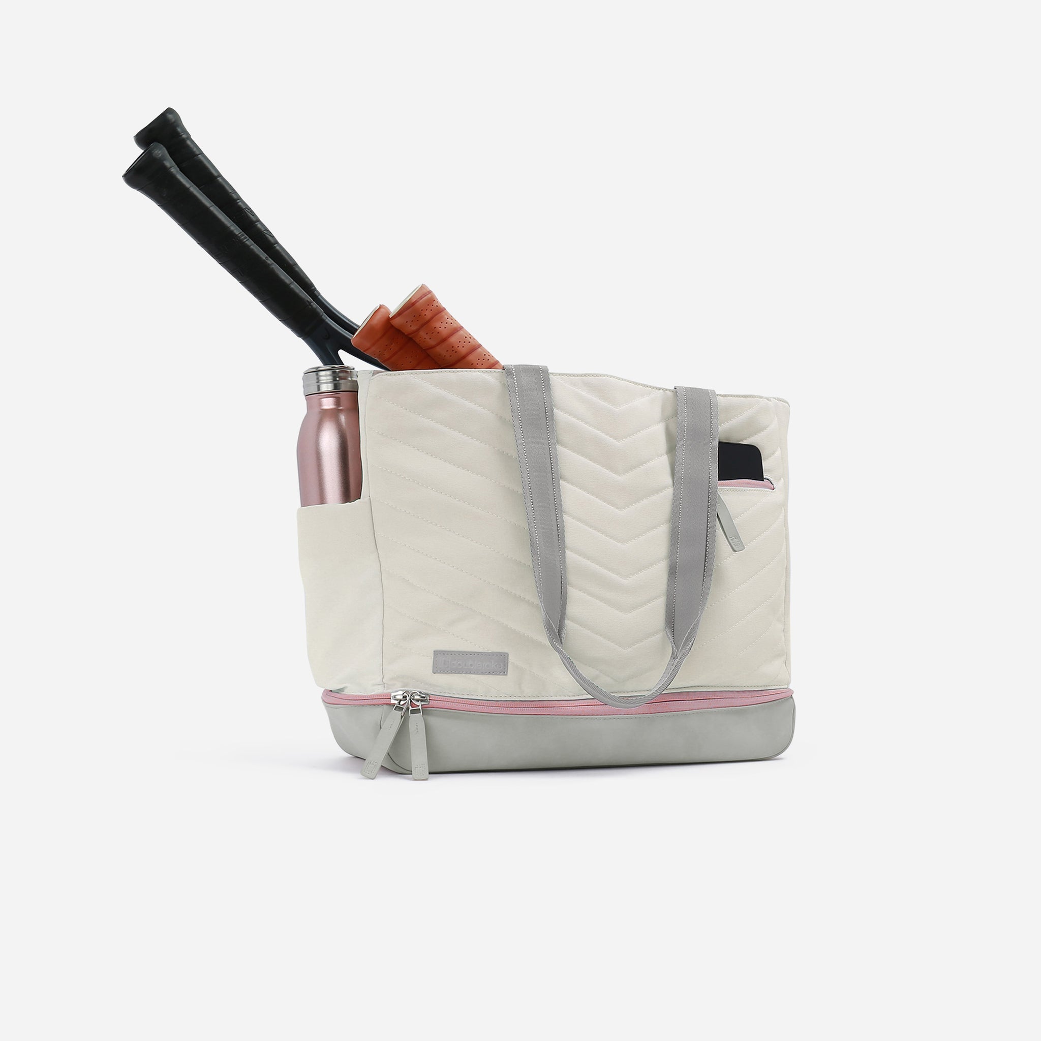 White quilted tote bag with tennis rackets and water bottle.