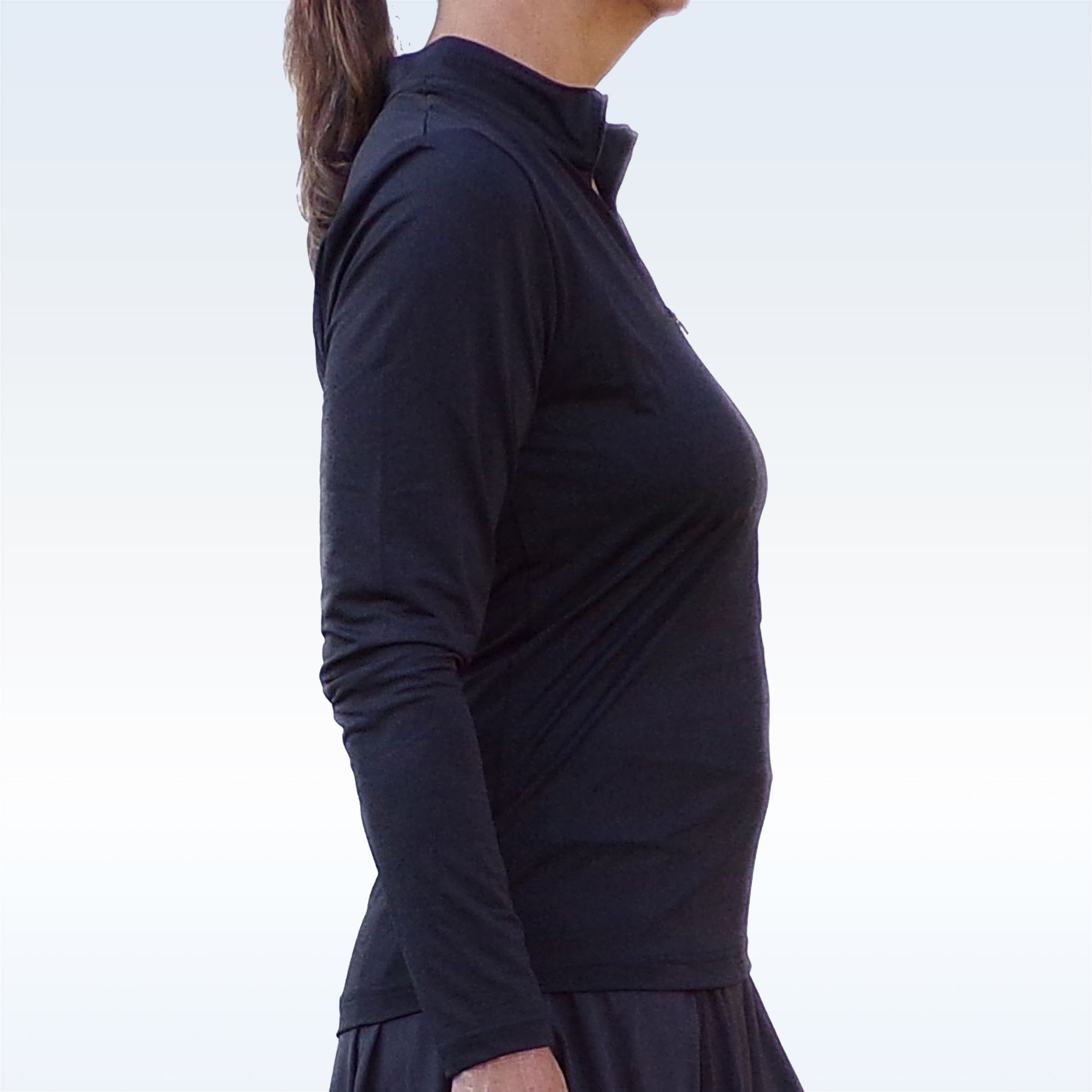 Black long sleeve 1/4 zip pullover by Pickleball Bella, with a stand-up collar and partial zipper, worn by a woman in a side view.