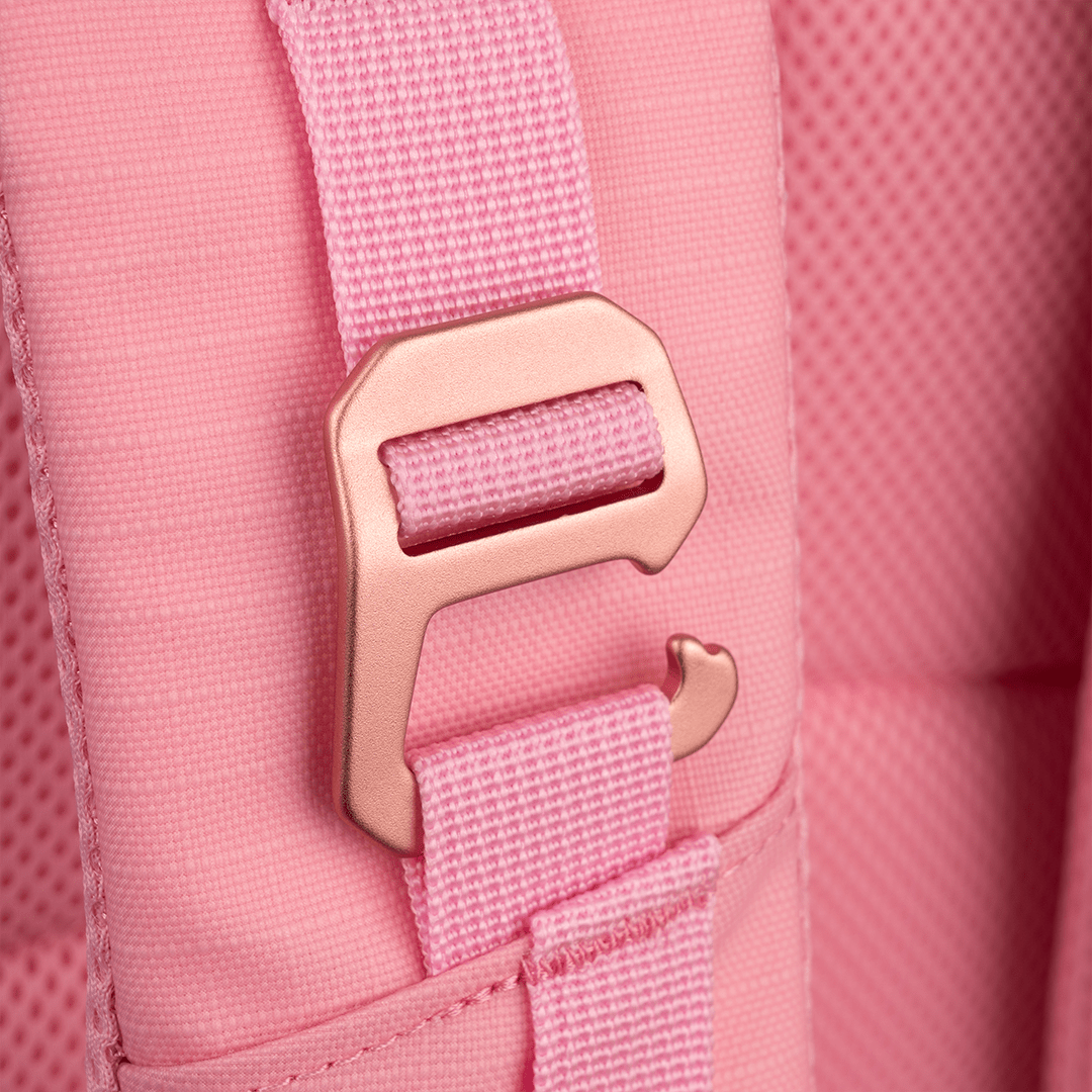 Pink Pickleball Backpack by FORWRD, close-up of a rose gold buckle on a woven strap and textured fabric.