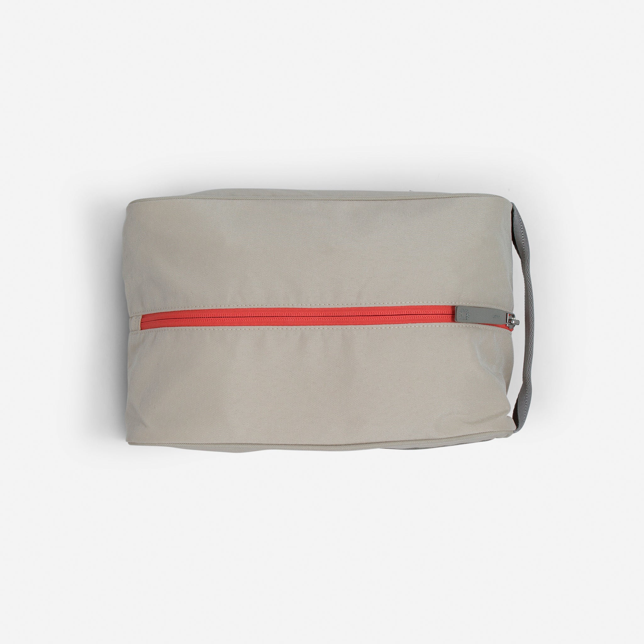 Beige toiletry bag with red zipper.