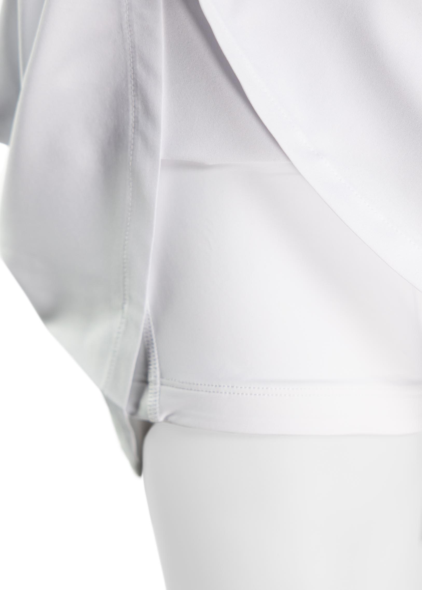 White Performance Mid-Rise Skort by TMPR Sports, with visible side seam stitching and layered fabric.