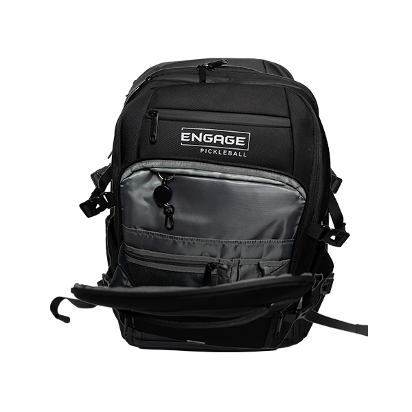 Black textured backpack by EngagePickleball, featuring an open grey front pocket with a key hook and the "ENGAGE PICKLEBALL" logo.