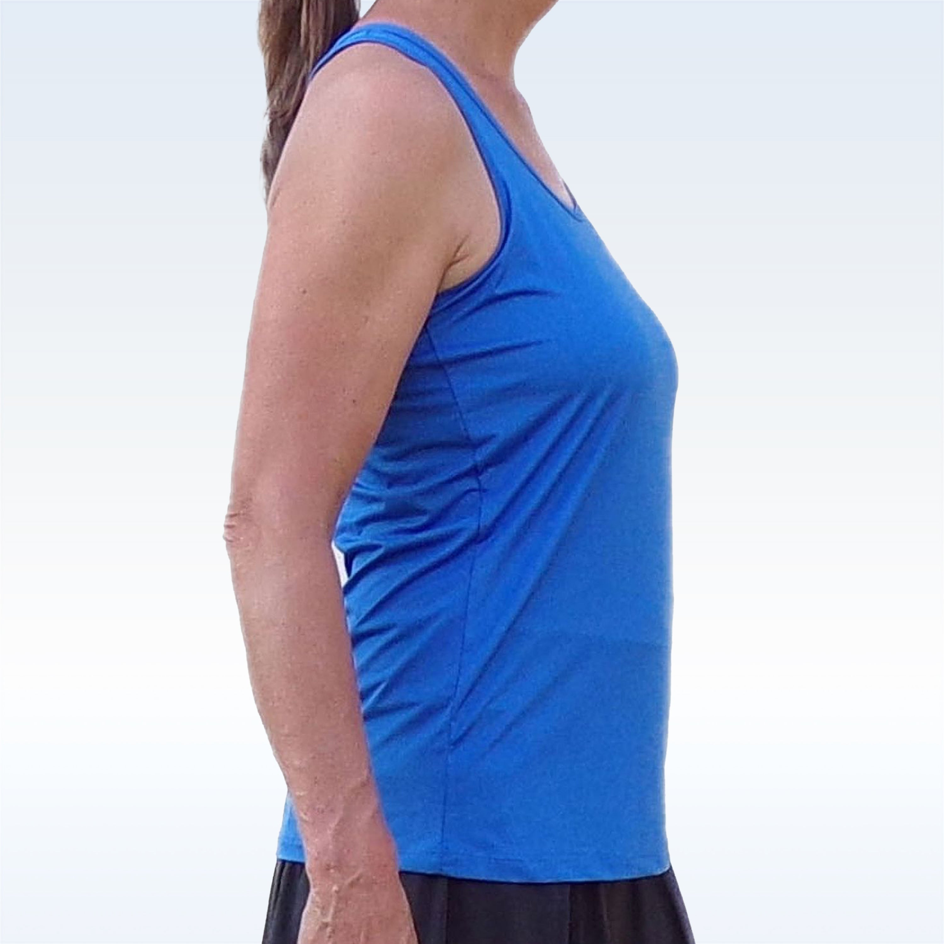 Royal Blue Racerback Tank by Pickleball Bella, shown from the side, worn by a woman with black shorts.