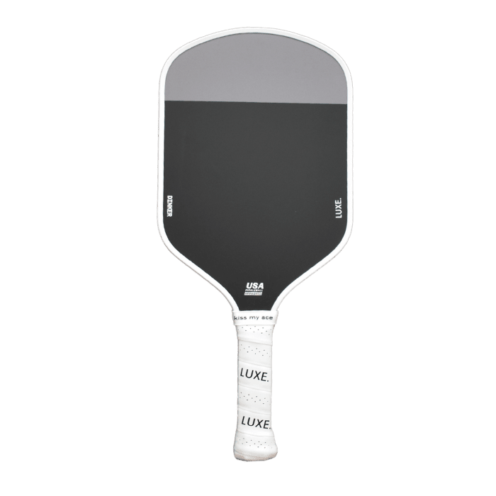 A black and gray pickleball paddle with a white handle grip that says "LUXE."