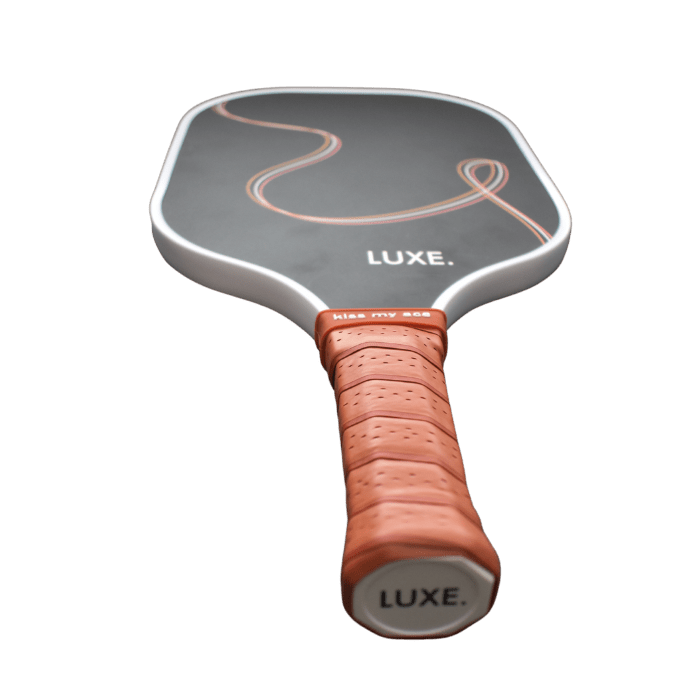 Pickleball paddle with a tan grip and "LUXE" branding.