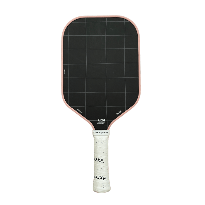 Pickleball paddle with pink trim, black hitting surface with white grid lines, and white grip.
