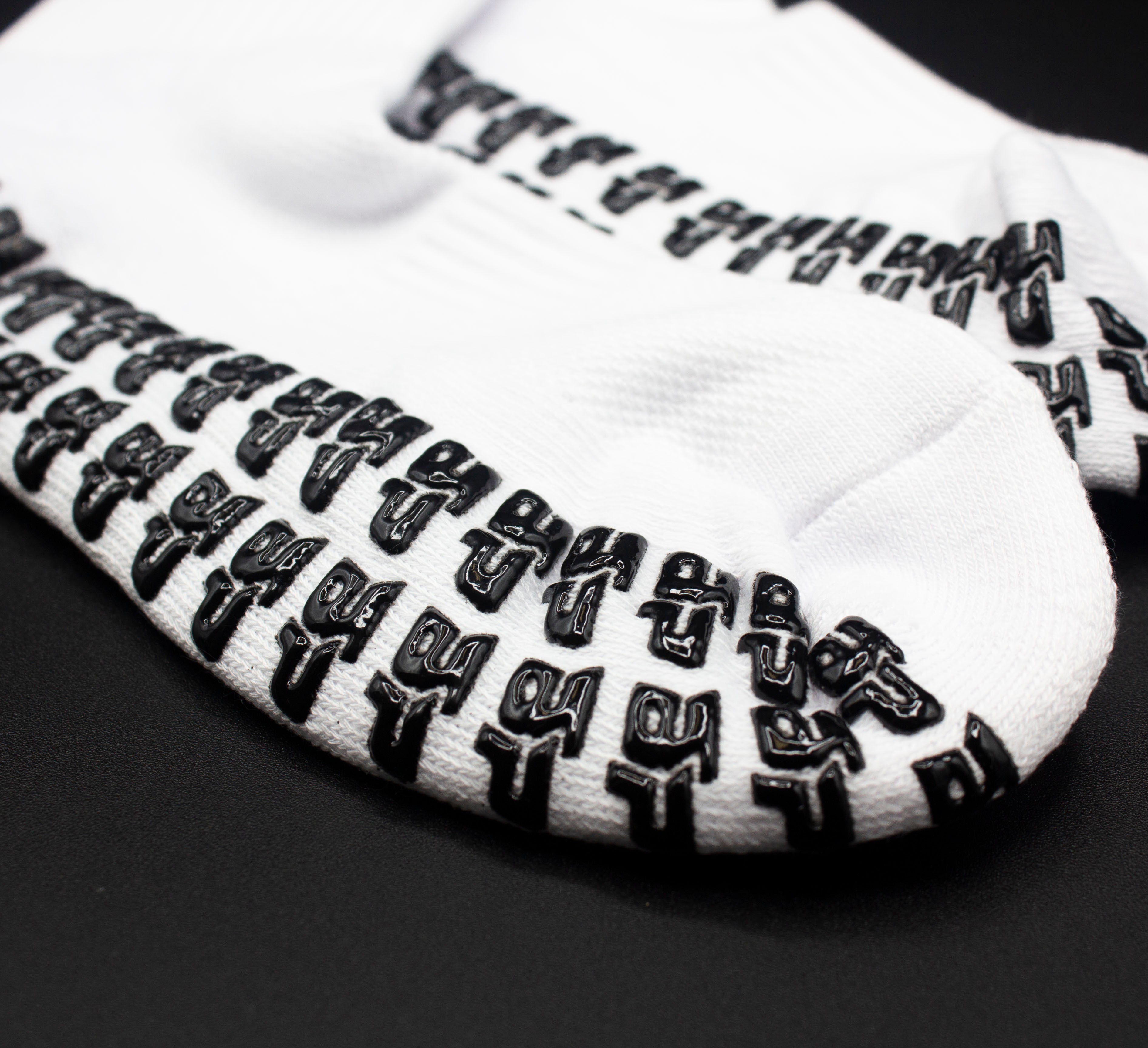 White Performance Socks by Bodhi Performance with black, raised anti-slip GRIPtech™ pattern on the sole.