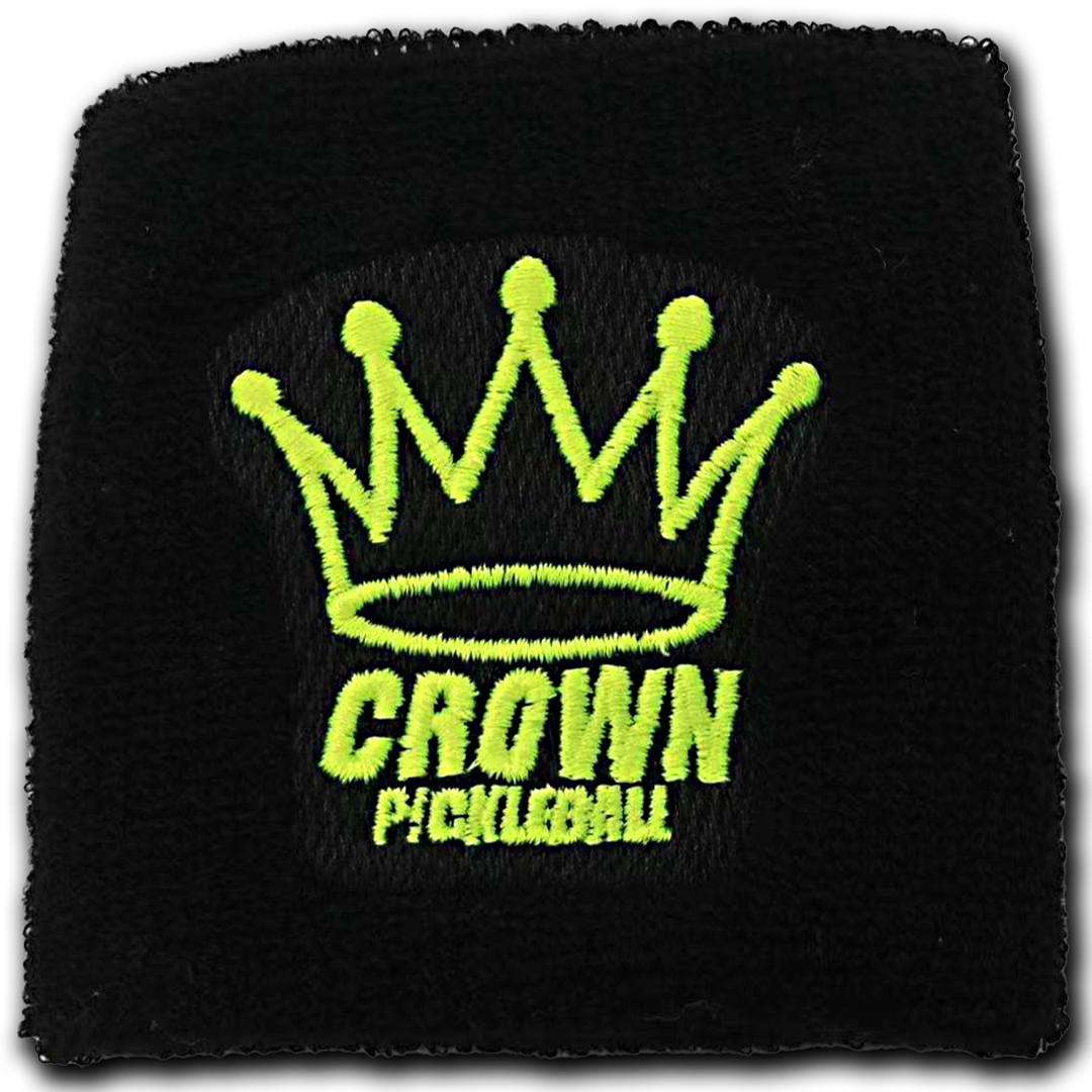 Close-up of a black sweatband with a neon green crown and "CROWN PICKLEBALL" embroidered on it.