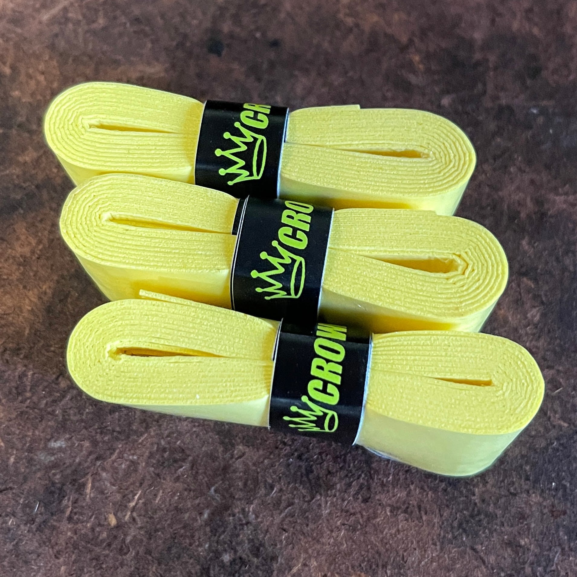 Three yellow rolls of grip tape with black labels.