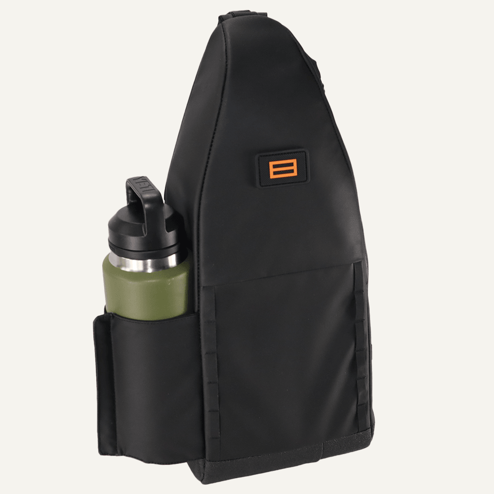 Black pickleball sling by FORWRD with an orange logo and a side pocket holding an olive green water bottle.