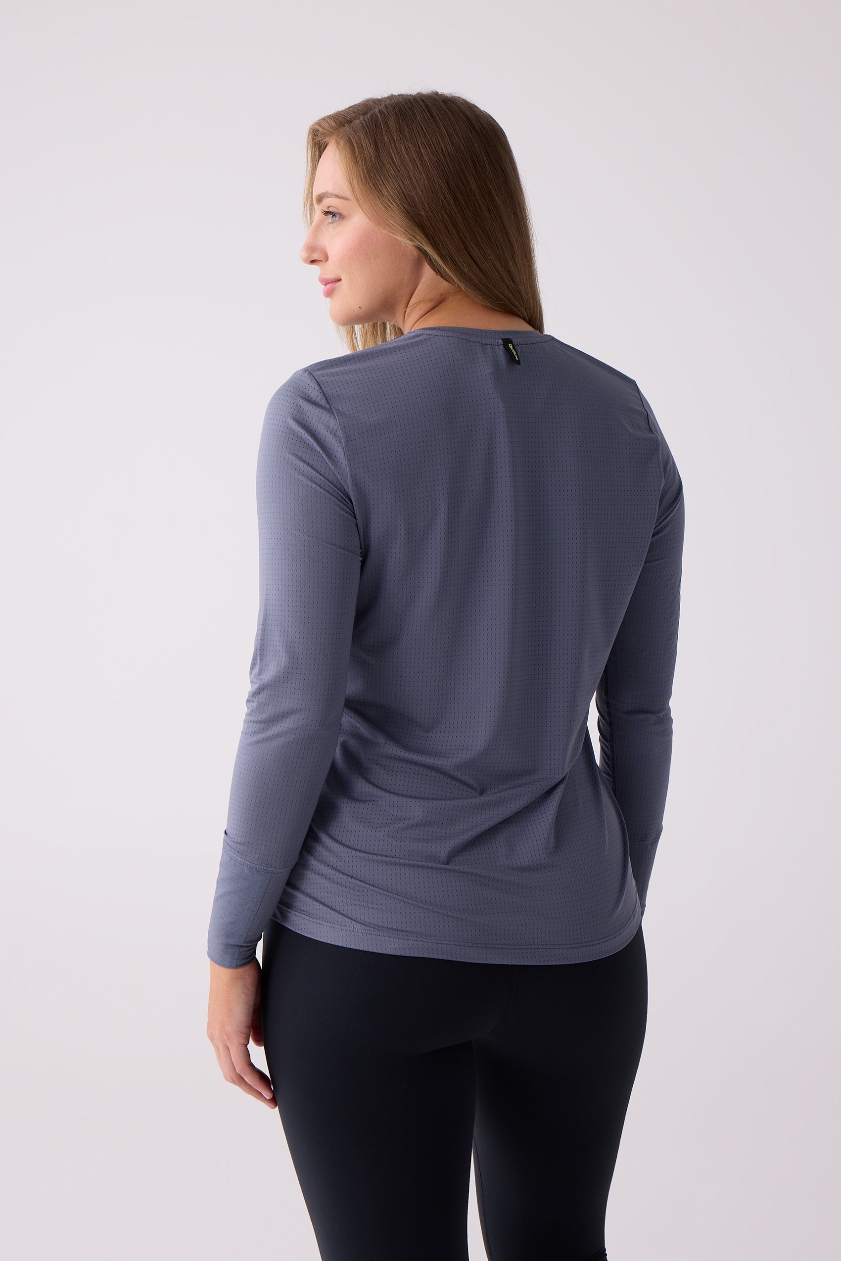Blue-gray long sleeve shirt with a perforated texture by Centerline Athletics, seen from the back on a model wearing black leggings.