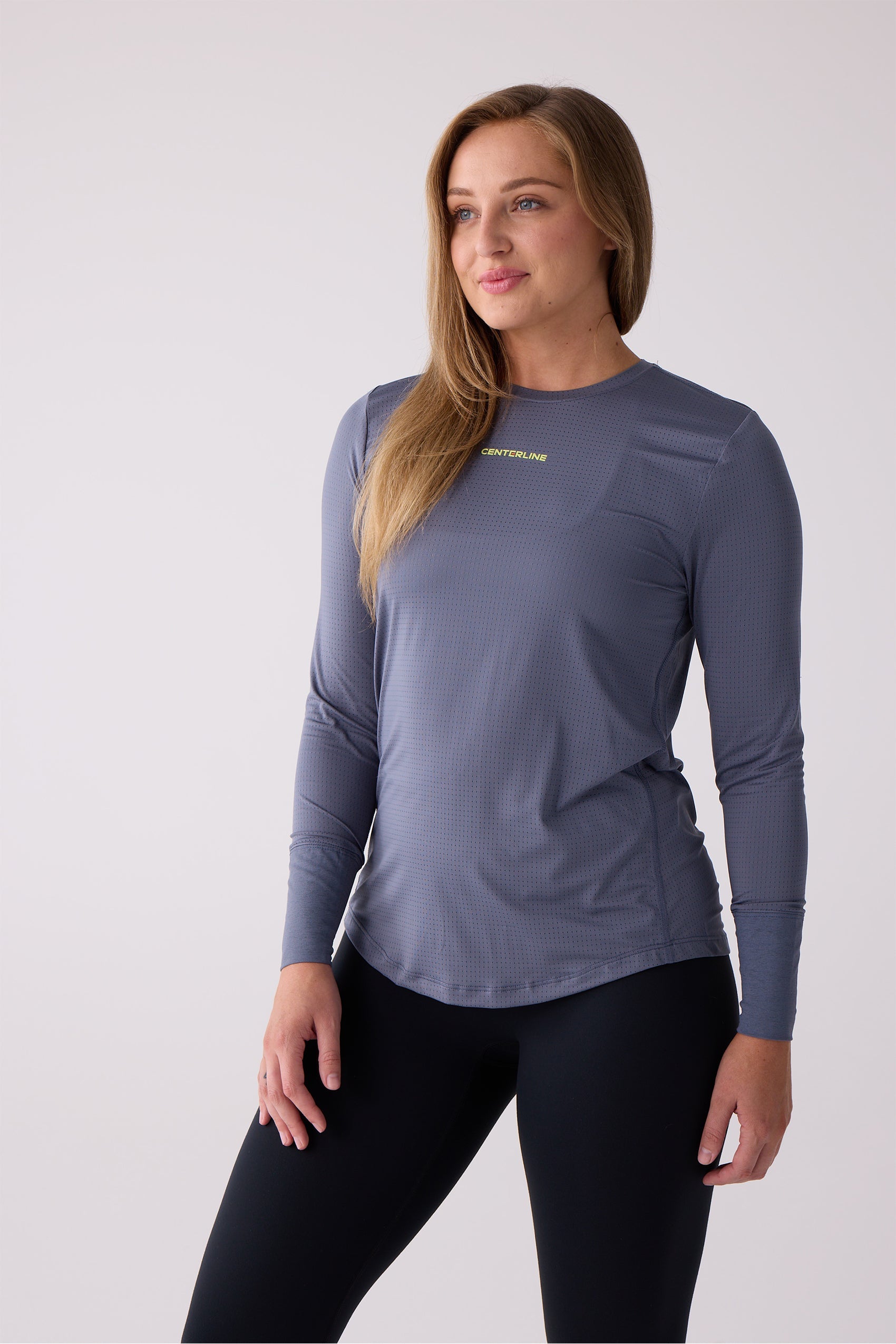 Women's slate blue long sleeve shirt with a micro-perforated texture by Centerline Athletics, featuring a yellow 'CENTERLINE' logo and worn with black leggings.