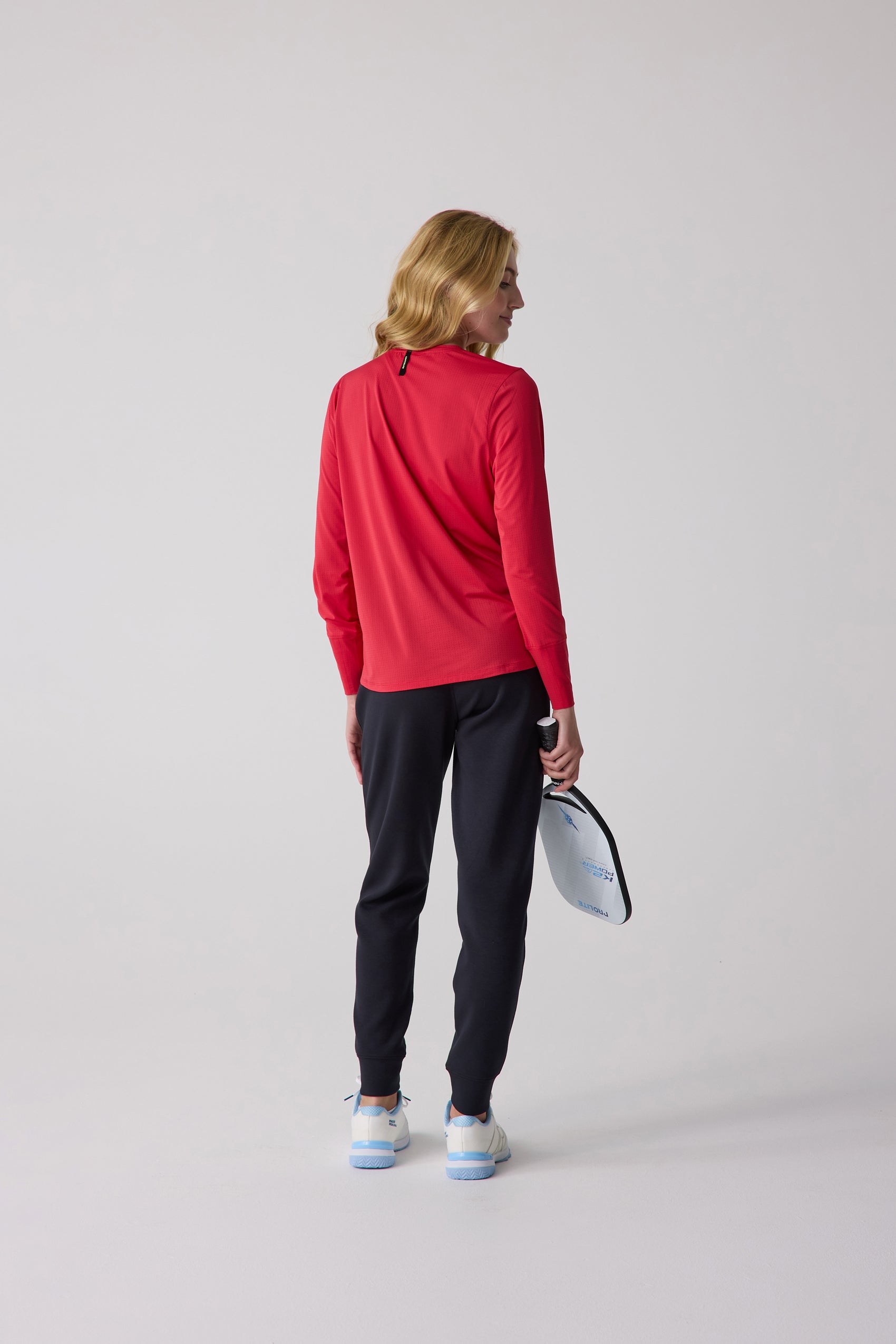 Red long sleeve shirt by Centerline Athletics with a subtle textured pattern, shown in a back view with black pants and a paddle.