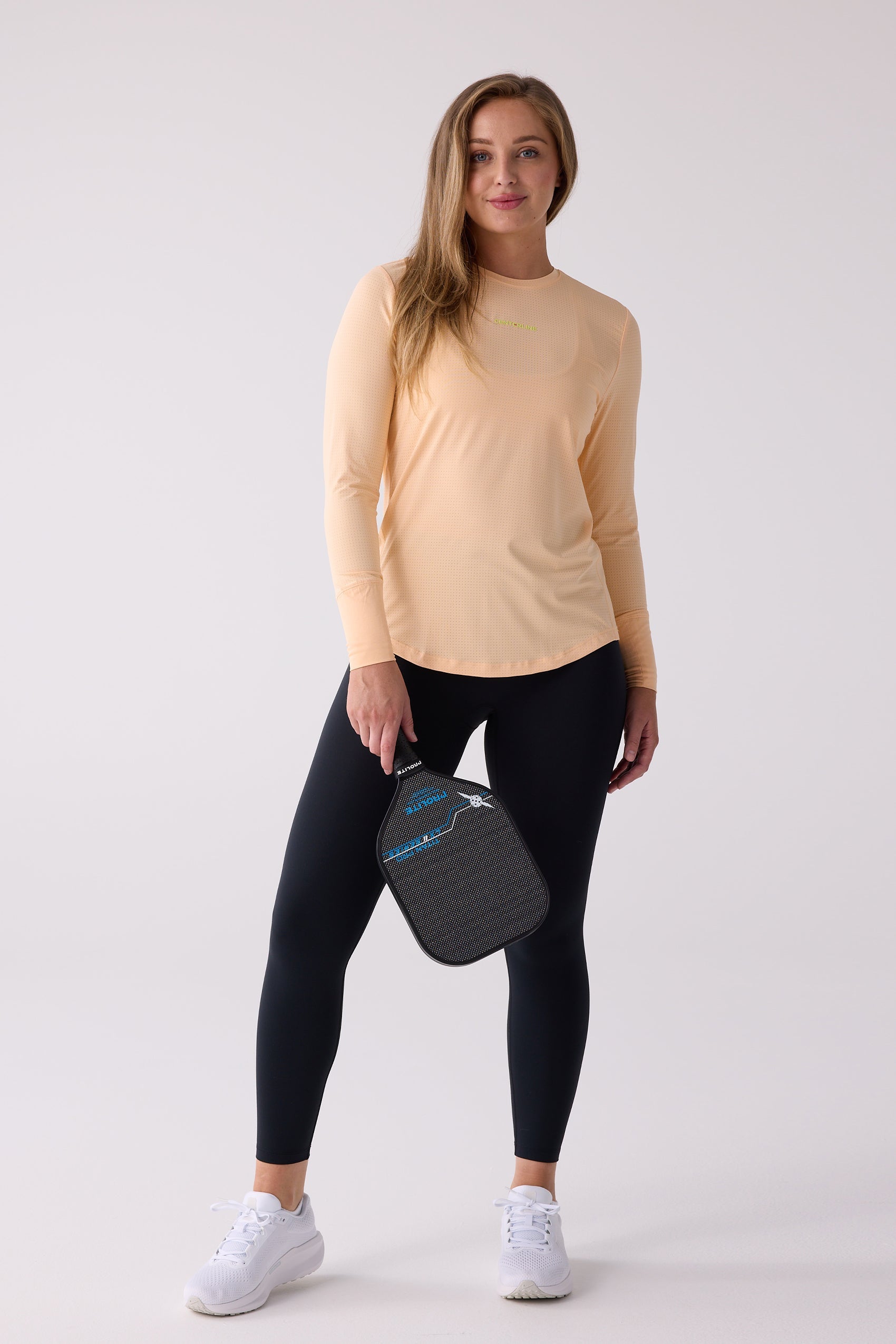 Peach women's long sleeve shirt by Centerline Athletics, featuring a perforated texture and neon yellow logo.