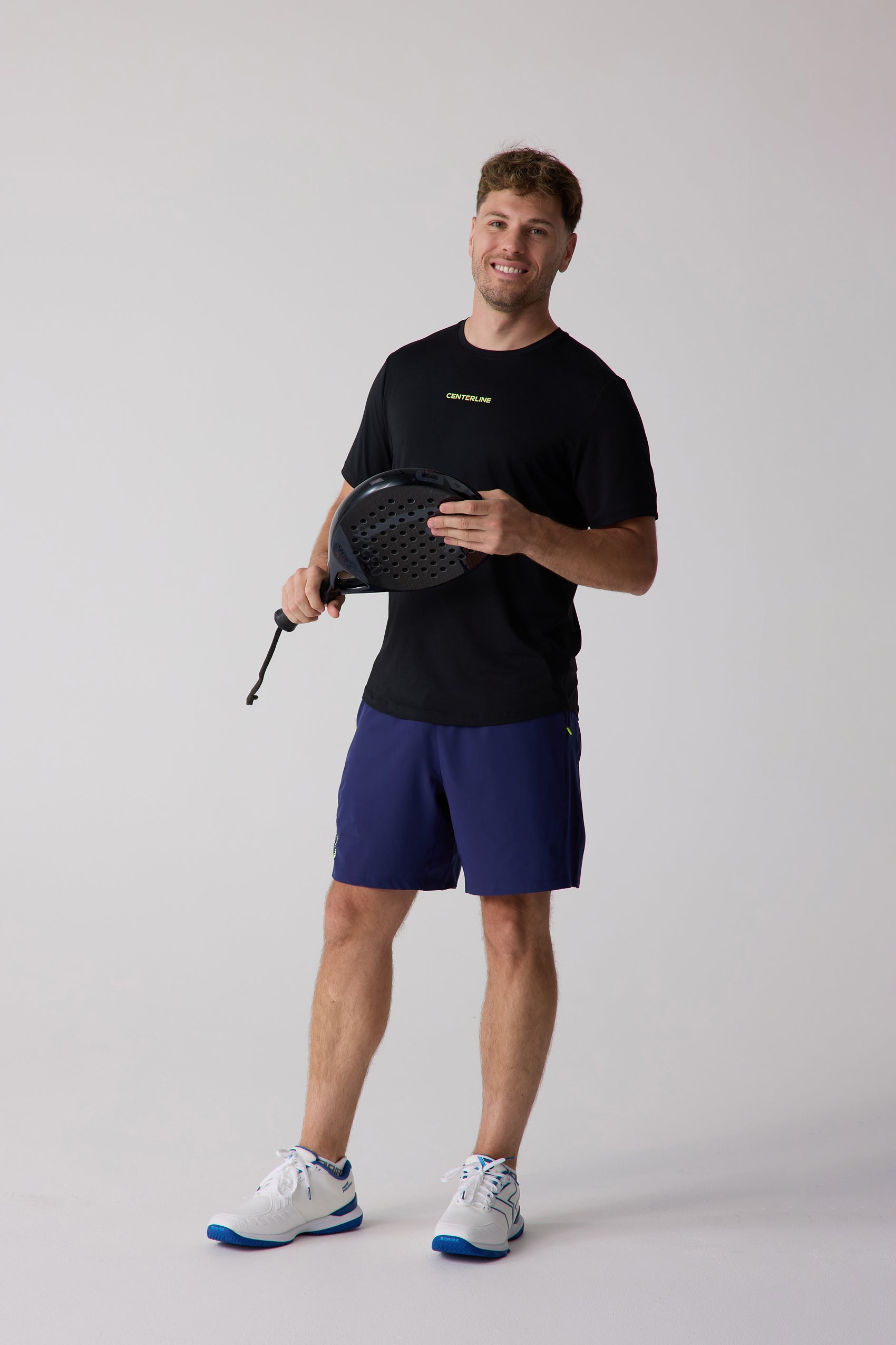 Black short-sleeved men's tee by Centerline Athletics with a yellow 'CENTERLINE' logo on the chest, worn by a man.