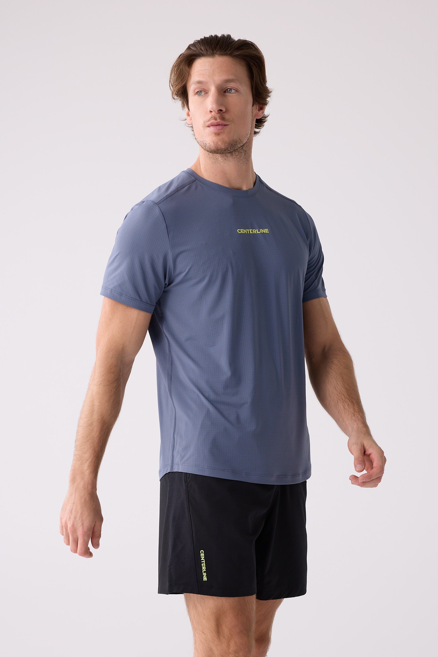 Blue-grey subtly patterned Men's AirLite Tee by Centerline Athletics, worn by a man with black shorts.