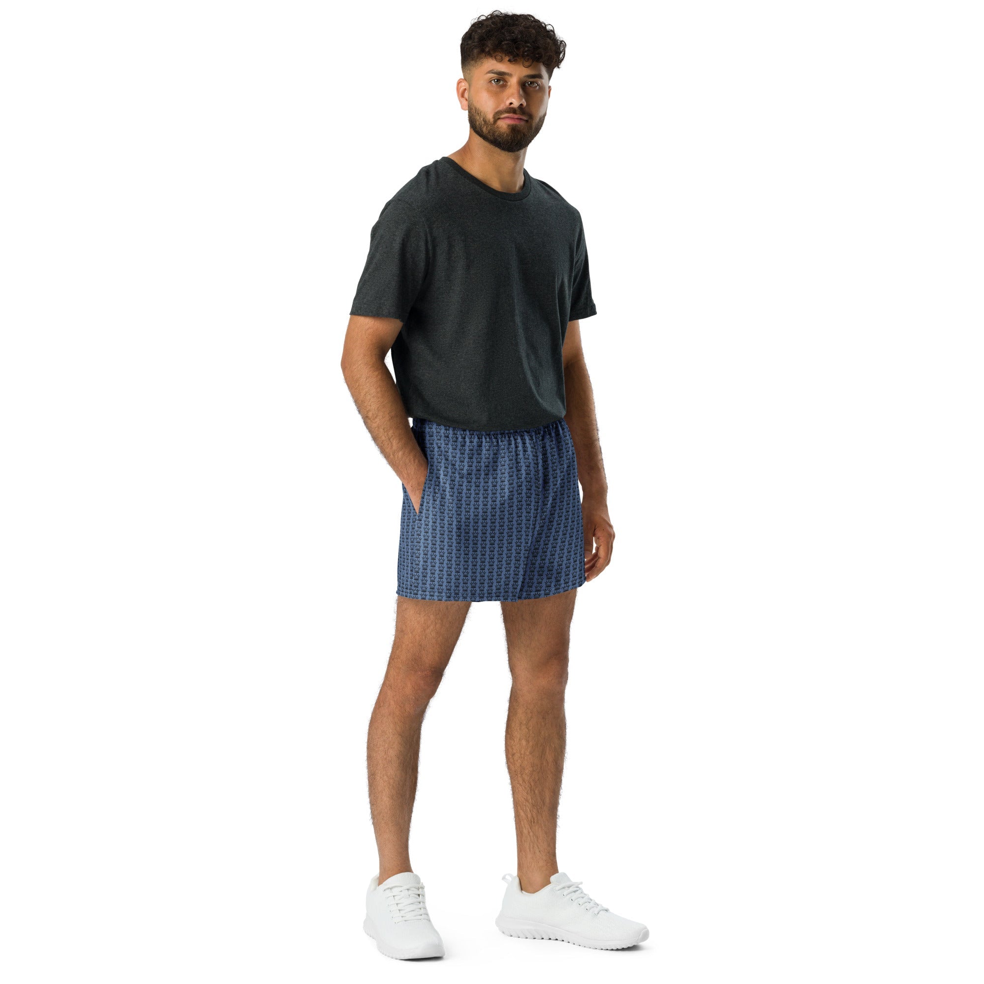 Man in a gray t-shirt and blue boxer shorts with white sneakers.

