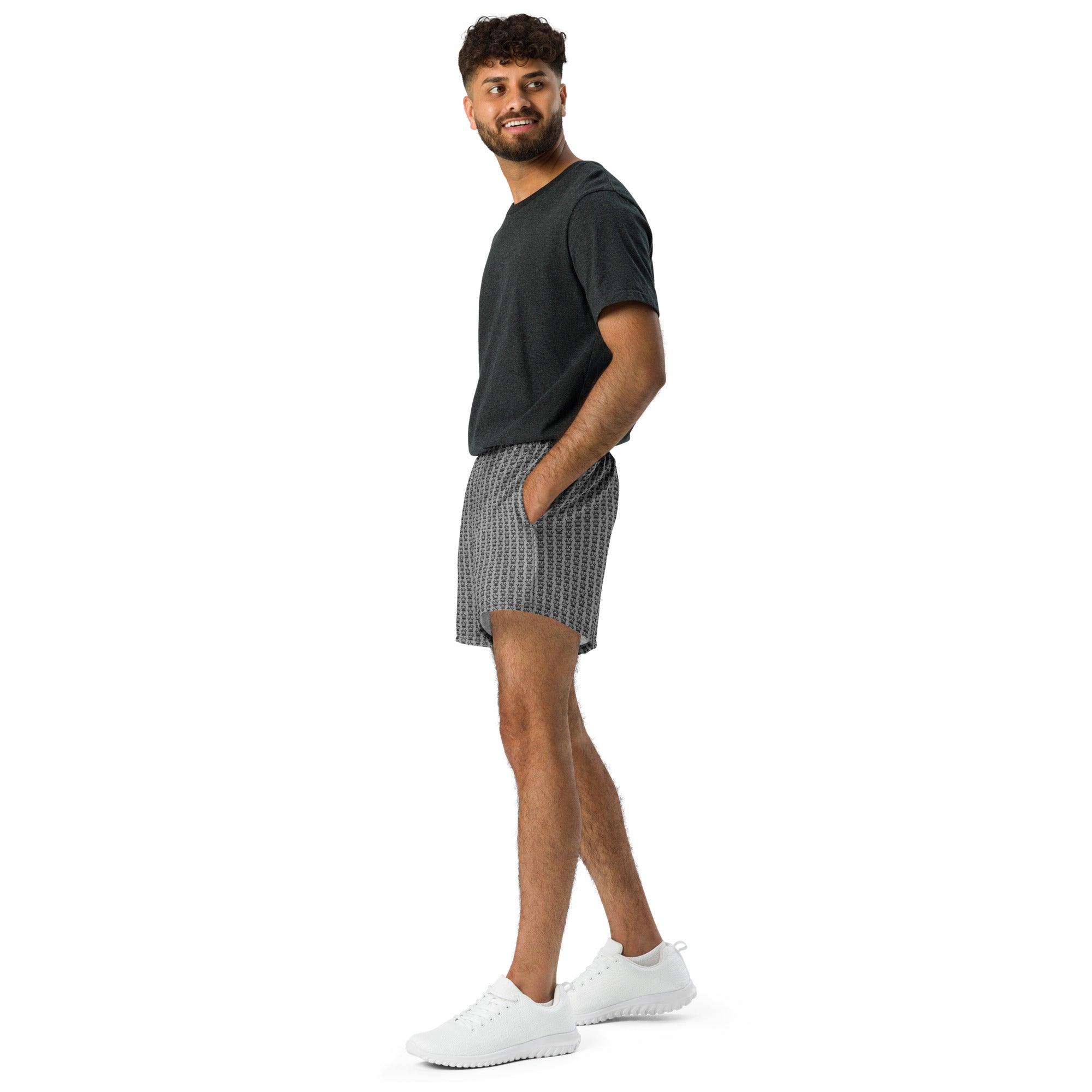Man in dark gray t-shirt, patterned shorts, and white shoes.