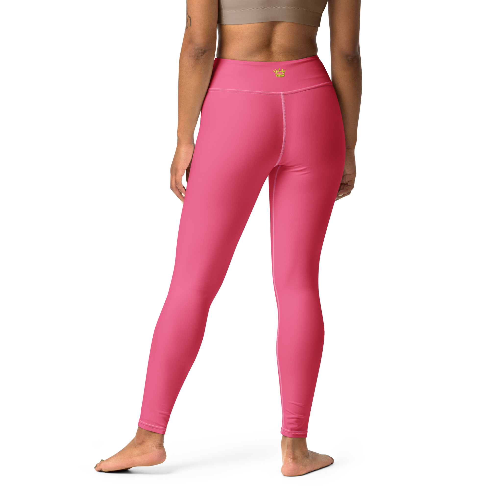 Back view of a woman in pink yoga pants and a tan sports bra.