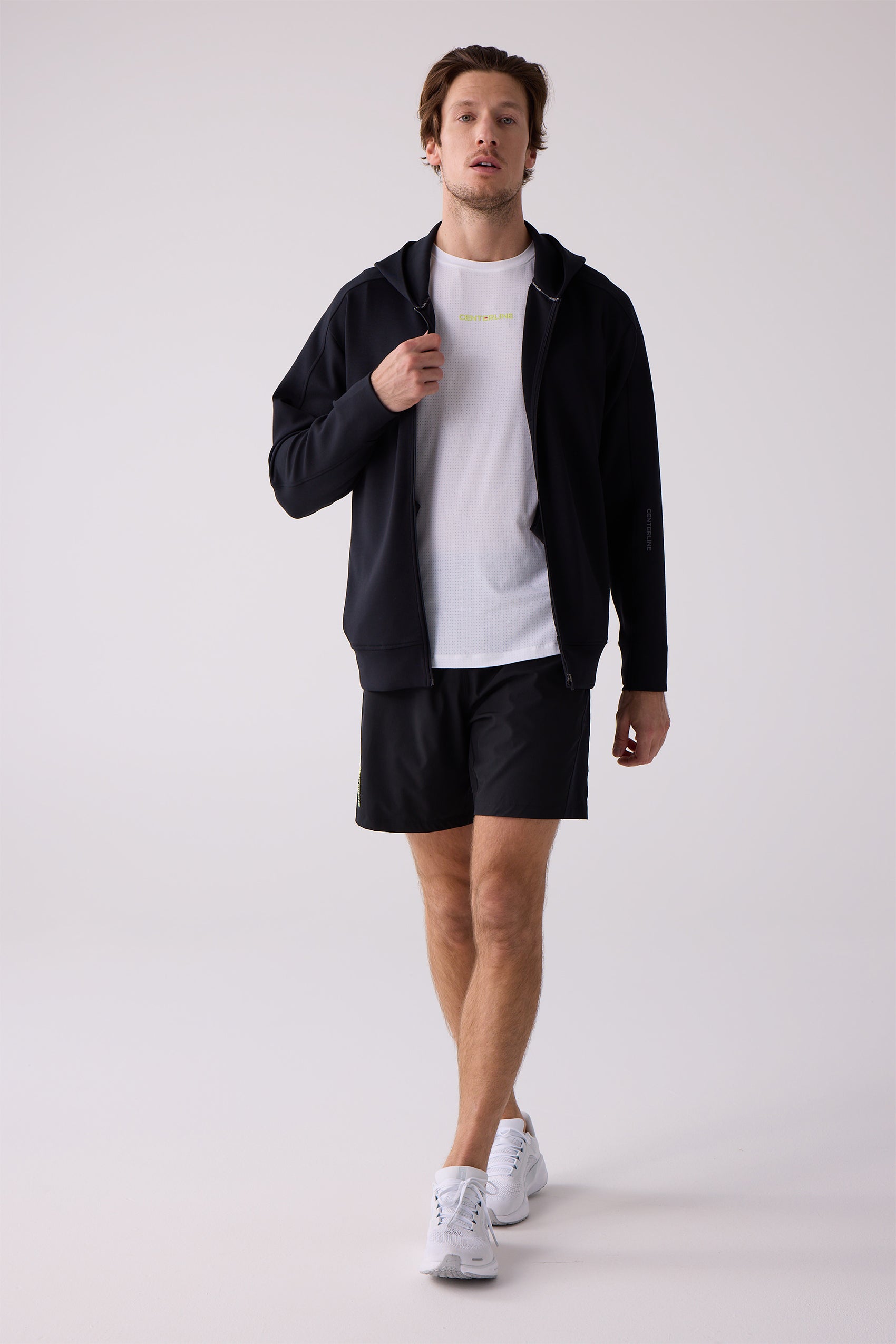 Black Unisex Crew Sweatshirt by Centerline Athletics with sleeve branding, worn over a white t-shirt and black shorts.