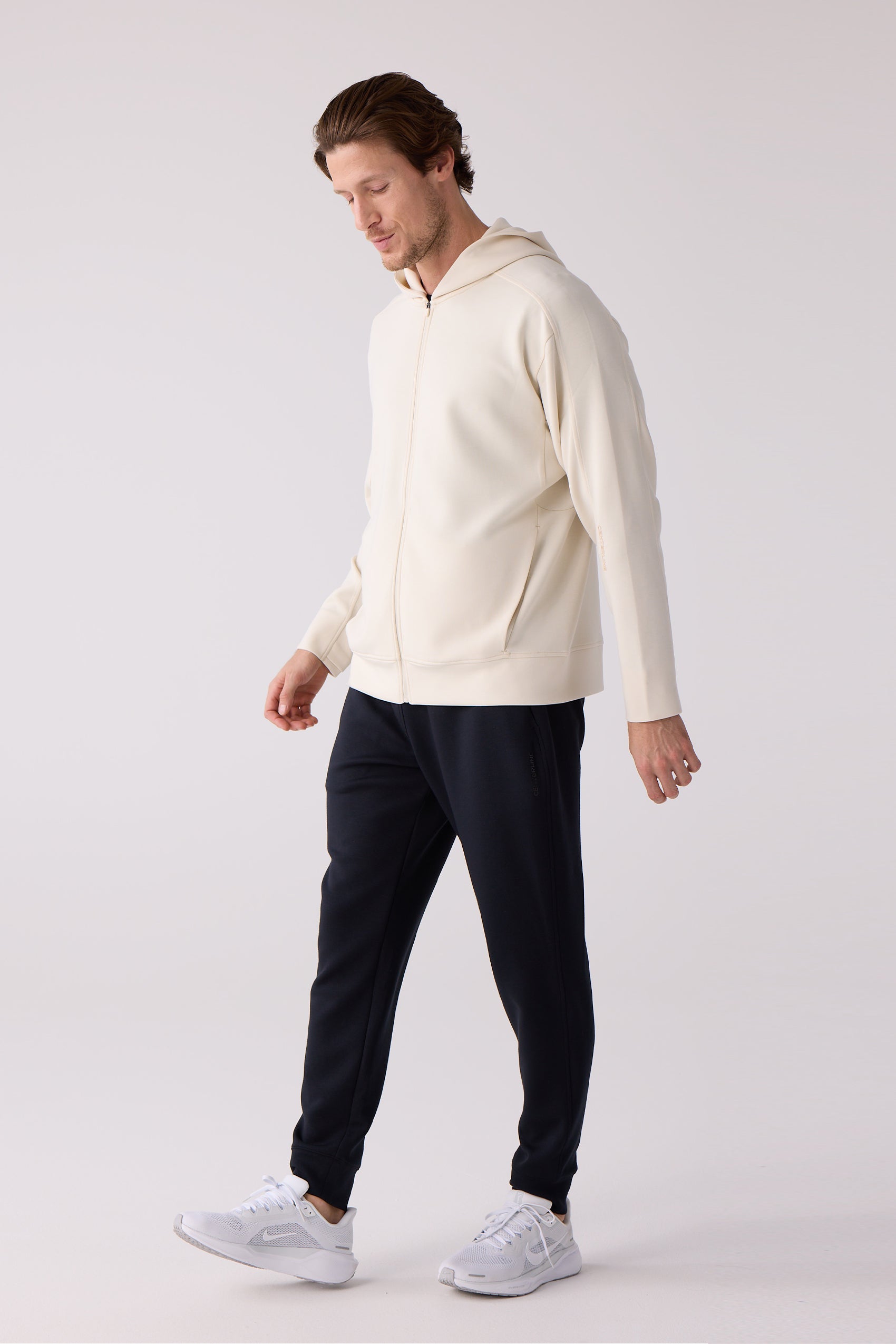 Cream full-zip hooded sweatshirt by Centerline Athletics, worn with dark joggers and white sneakers.