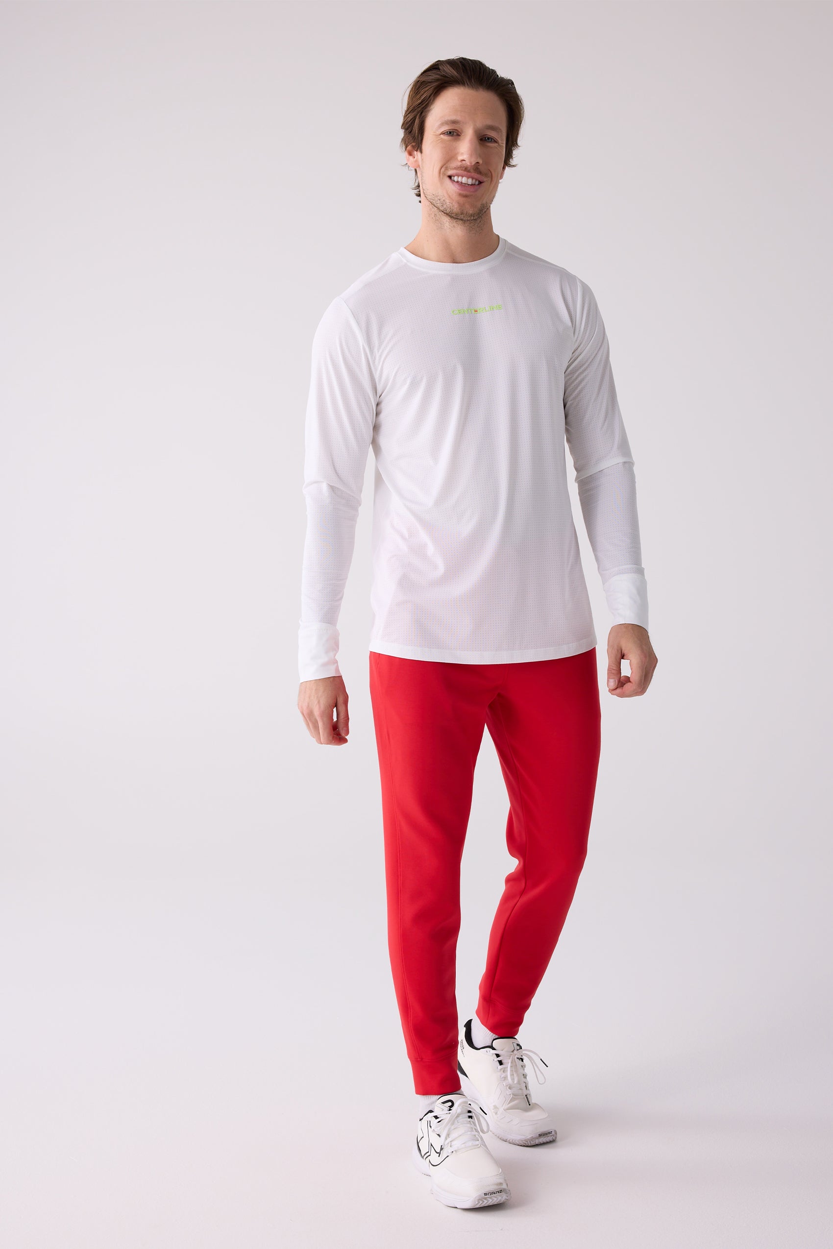 Red Men's Après Jogger from Centerline Athletics, styled with a white textured long-sleeve shirt and white athletic sneakers.
