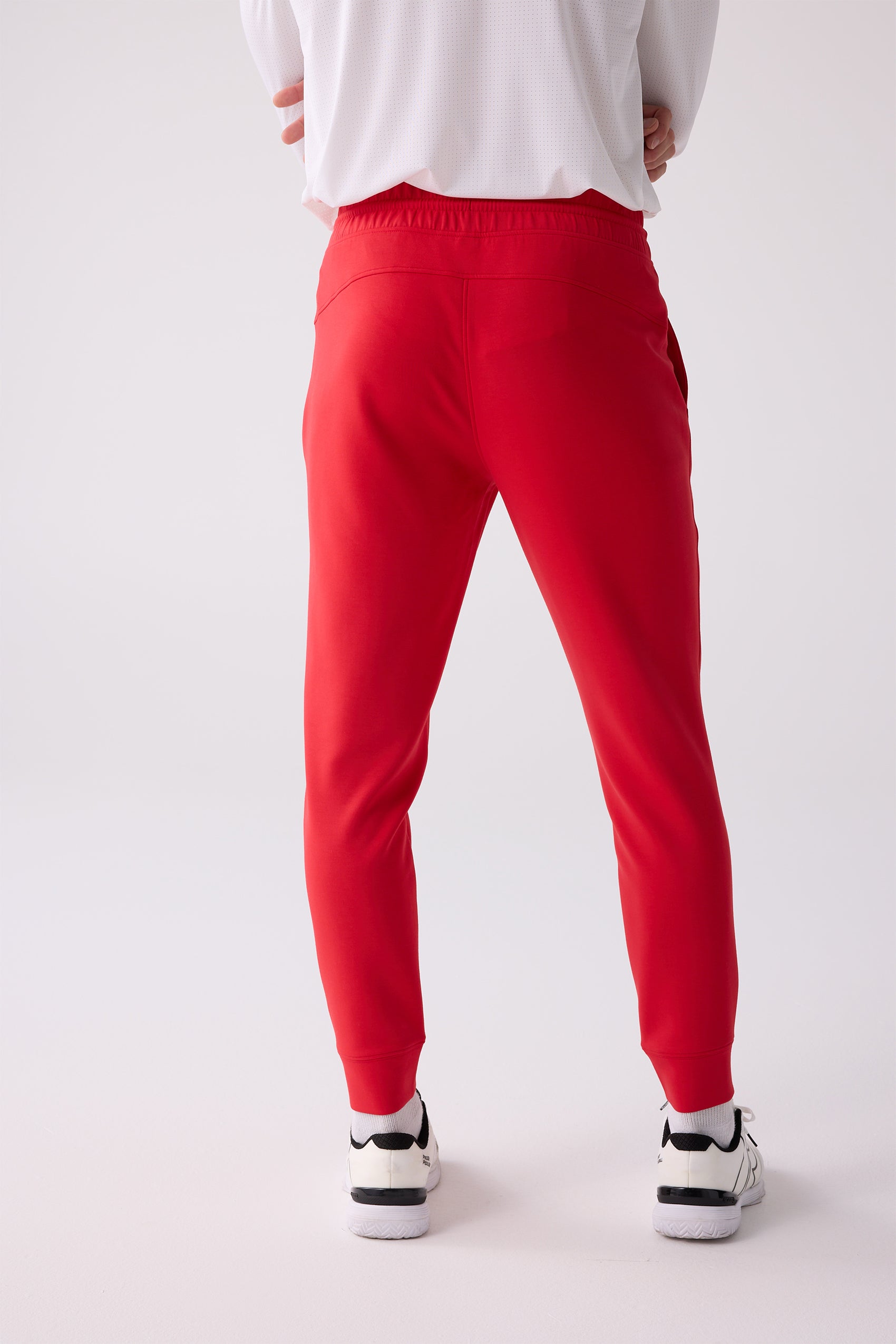Red Men's Après Jogger by Centerline Athletics, shown from the back with an elastic waistband, worn with a white shirt and sneakers.