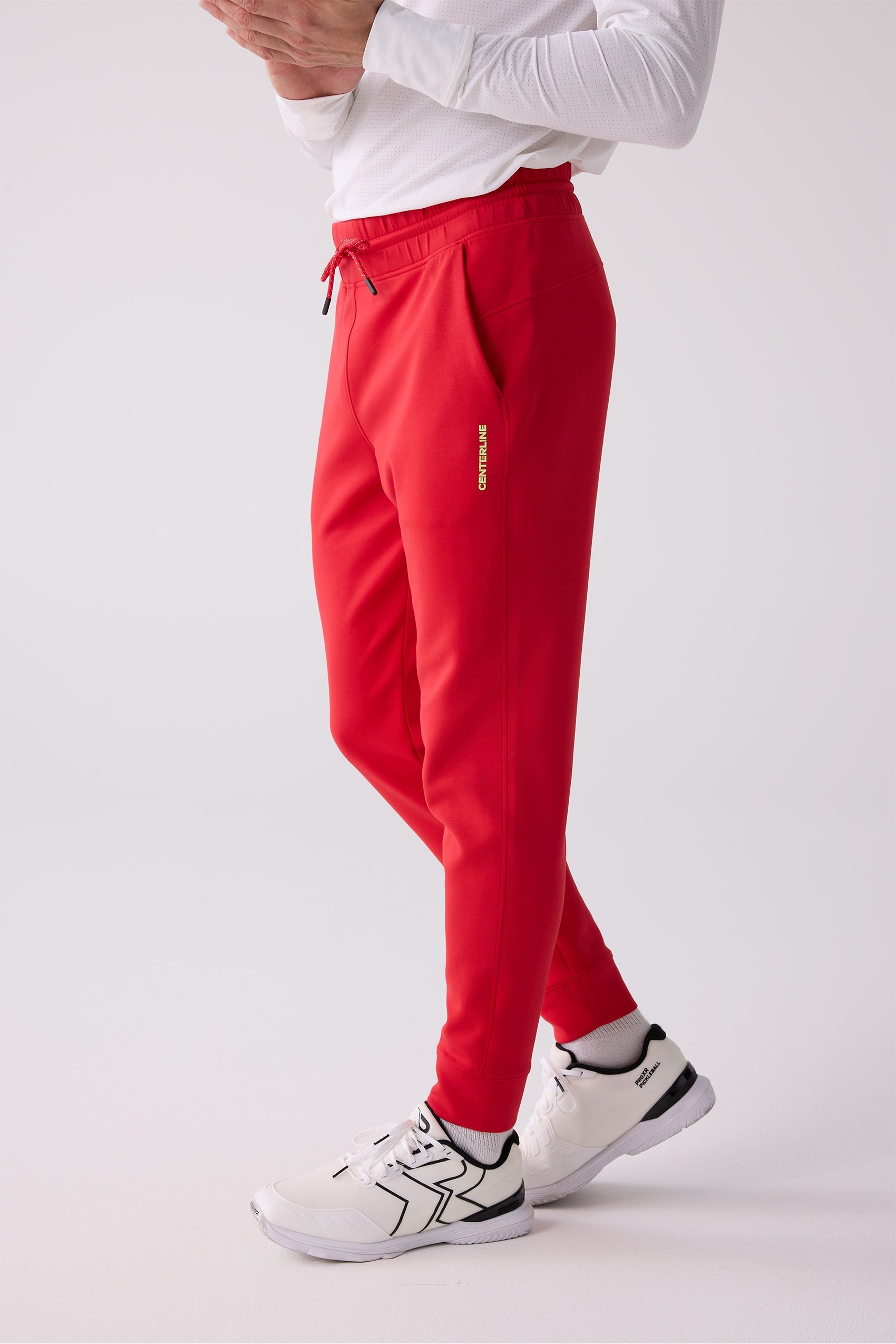 Red men's Après Jogger by Centerline Athletics, featuring a drawstring waist, side pockets, and yellow vertical brand text.
