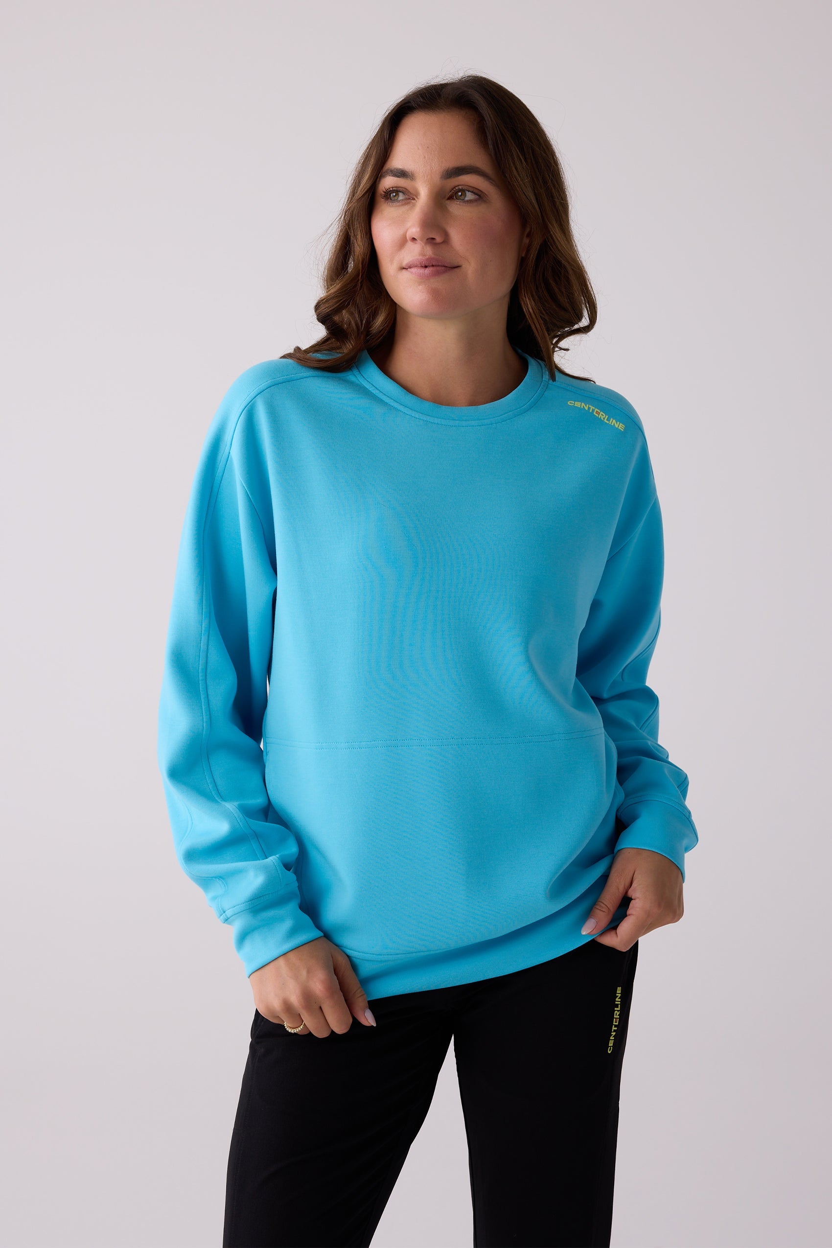 Blue women's crew sweatshirt by Centerline Athletics, featuring yellow 'CENTERLINE' text on the shoulder, worn with black pants.
