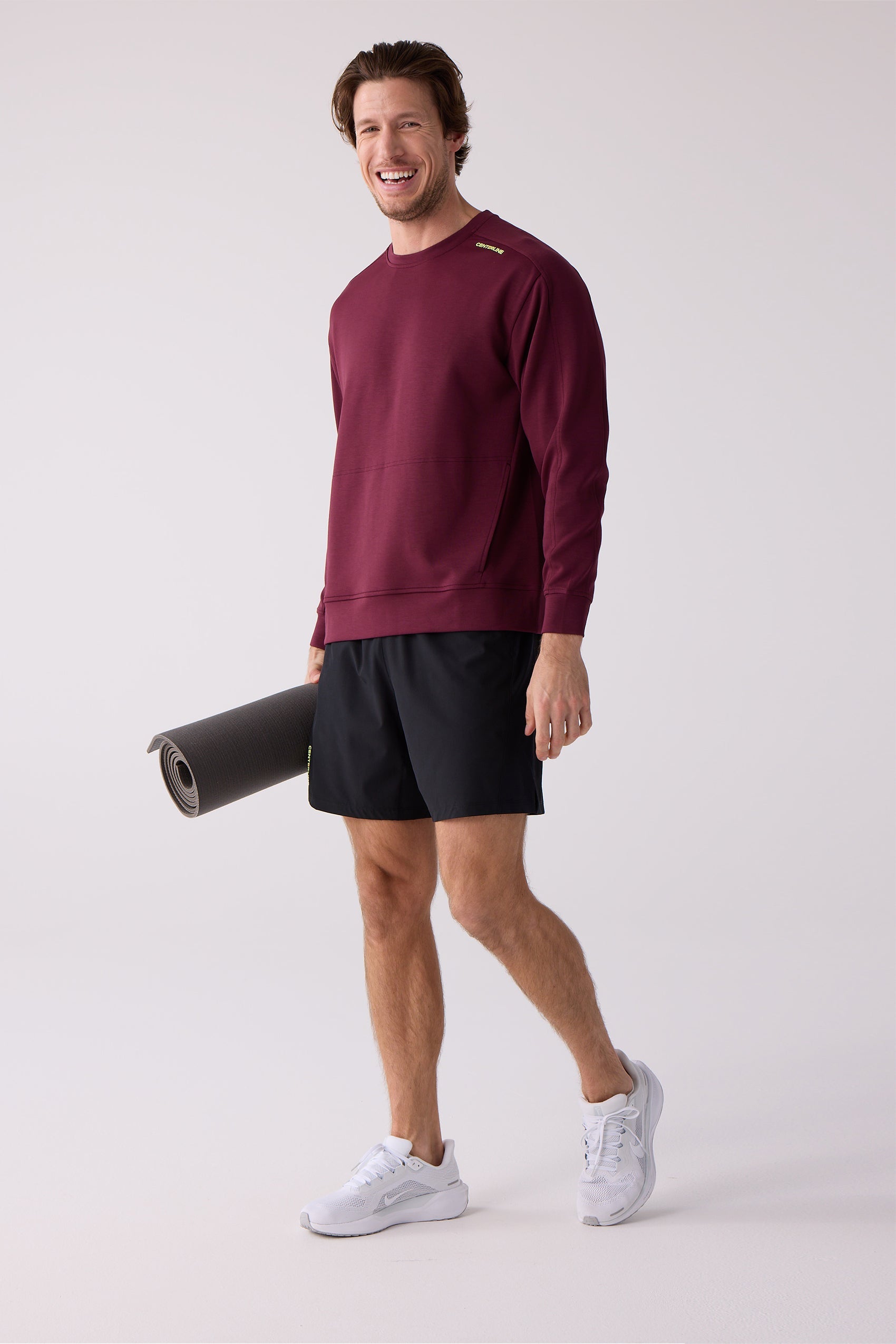Maroon crew sweatshirt by Centerline Athletics, with yellow shoulder text and a kangaroo pocket, worn by a man holding a yoga mat.