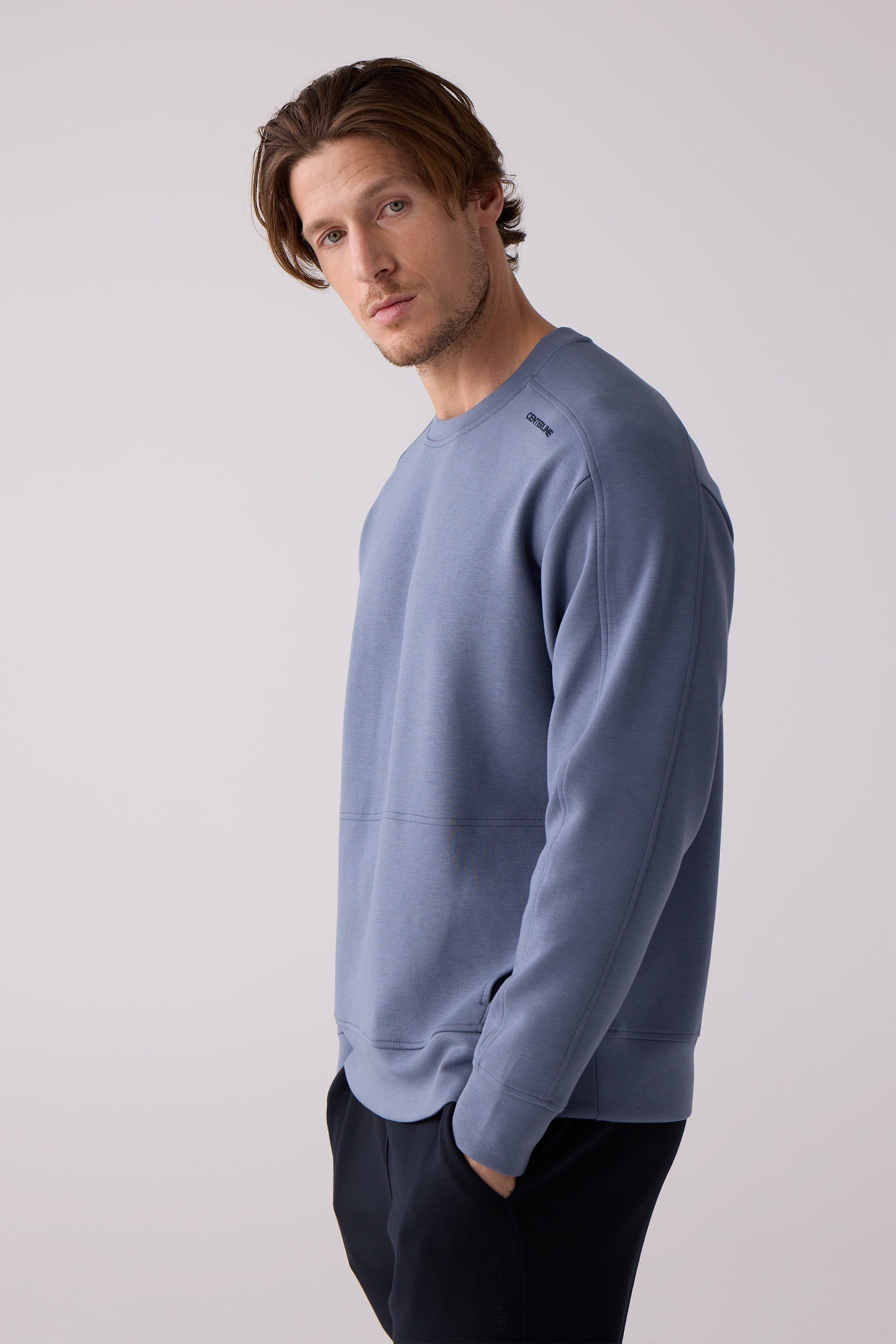 Men's slate blue crew sweatshirt by Centerline Athletics, featuring 'CENTERLINE' embroidery on shoulder and distinct seam details, paired with dark pants.