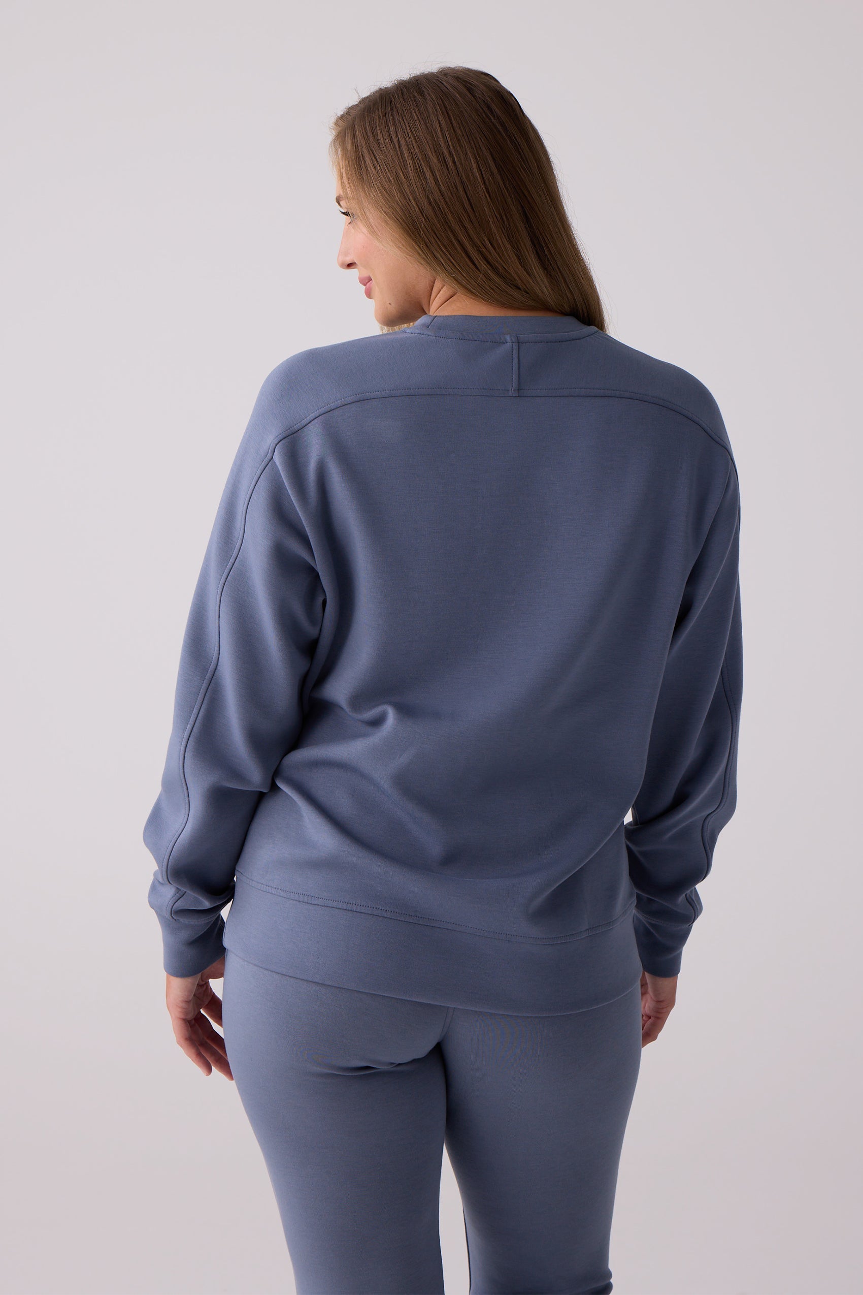 Blue women's crew sweatshirt by Centerline Athletics, shown from the back with distinctive stitching on the shoulders and back, paired with matching pants.
