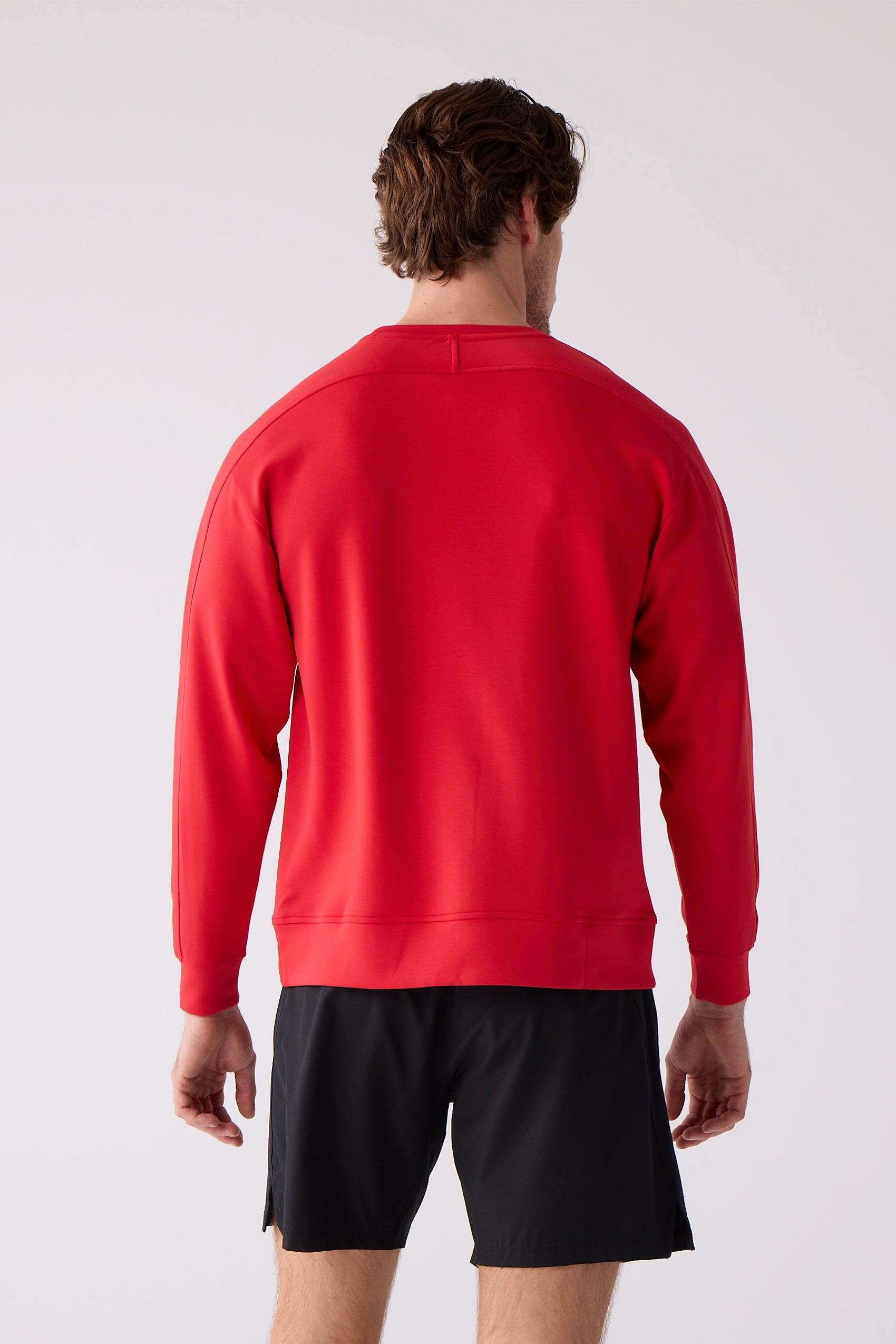 Red crew sweatshirt by Centerline Athletics, featuring raglan sleeves, seen from the back on a model wearing black shorts.
