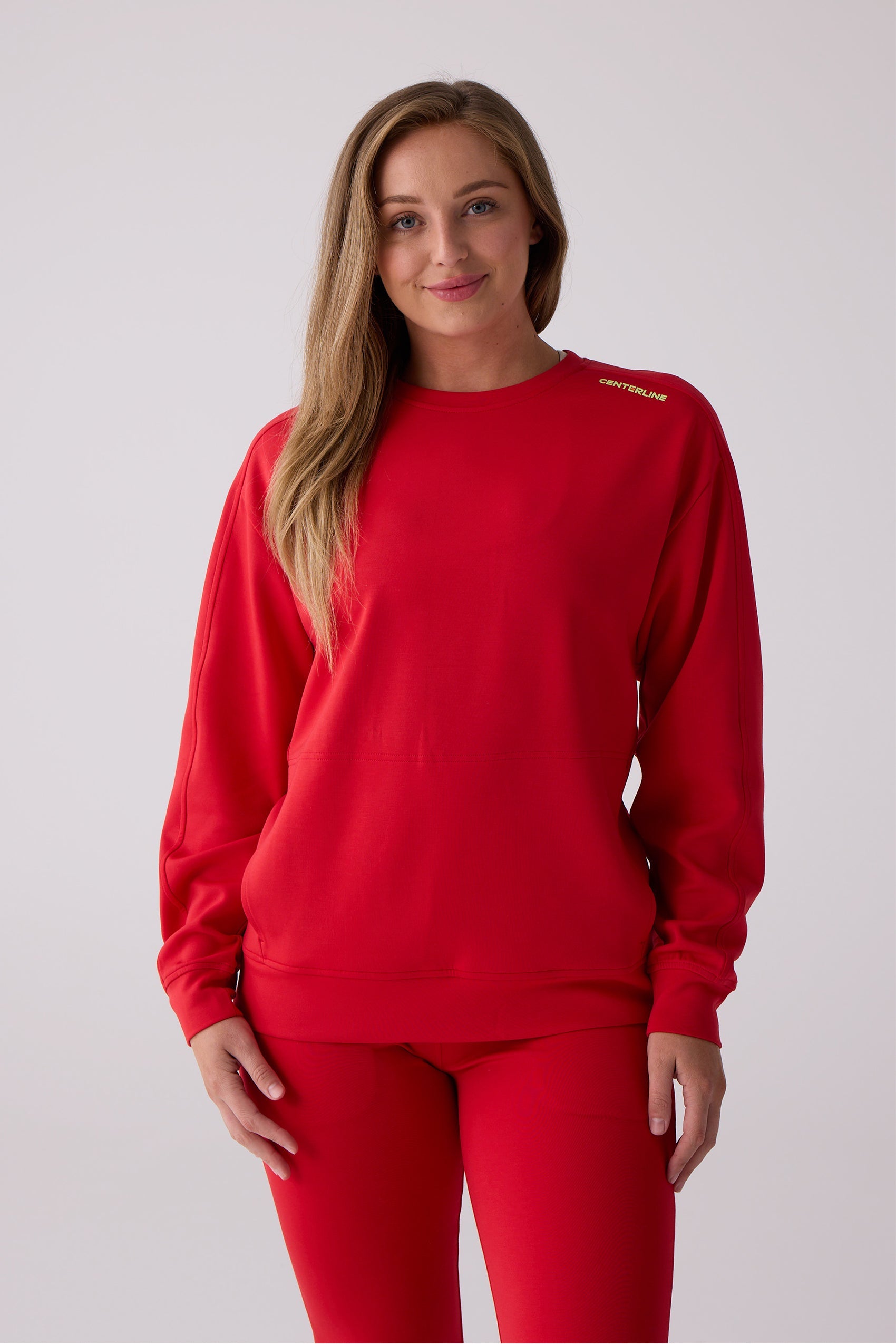 Red Crew Sweatshirt by Centerline Athletics, featuring 'CENTERLINE' text on the shoulder, paired with matching red leggings.