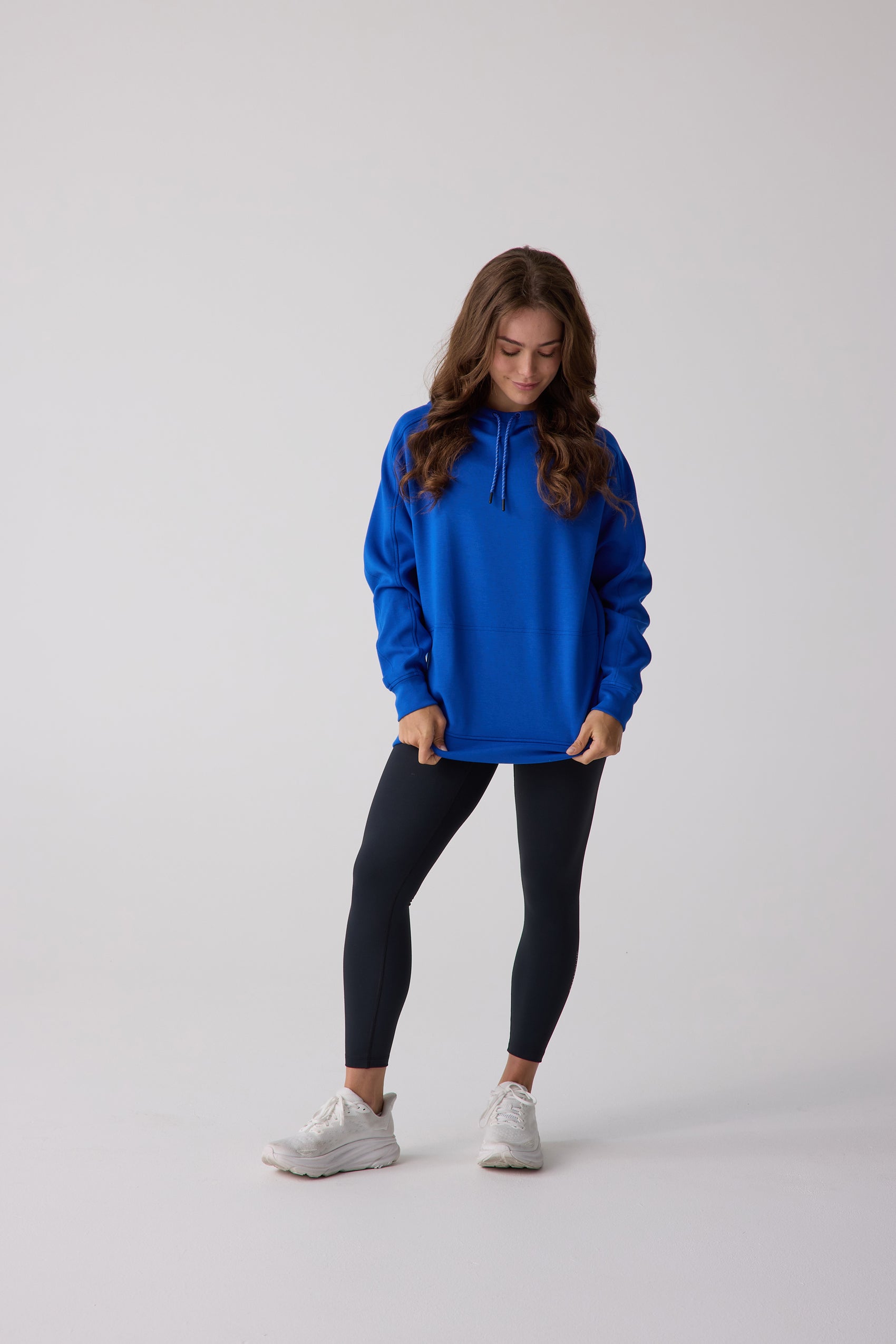 Blue women's hooded sweatshirt by Centerline Athletics, oversized with a drawstring hood, worn by a model with black leggings.