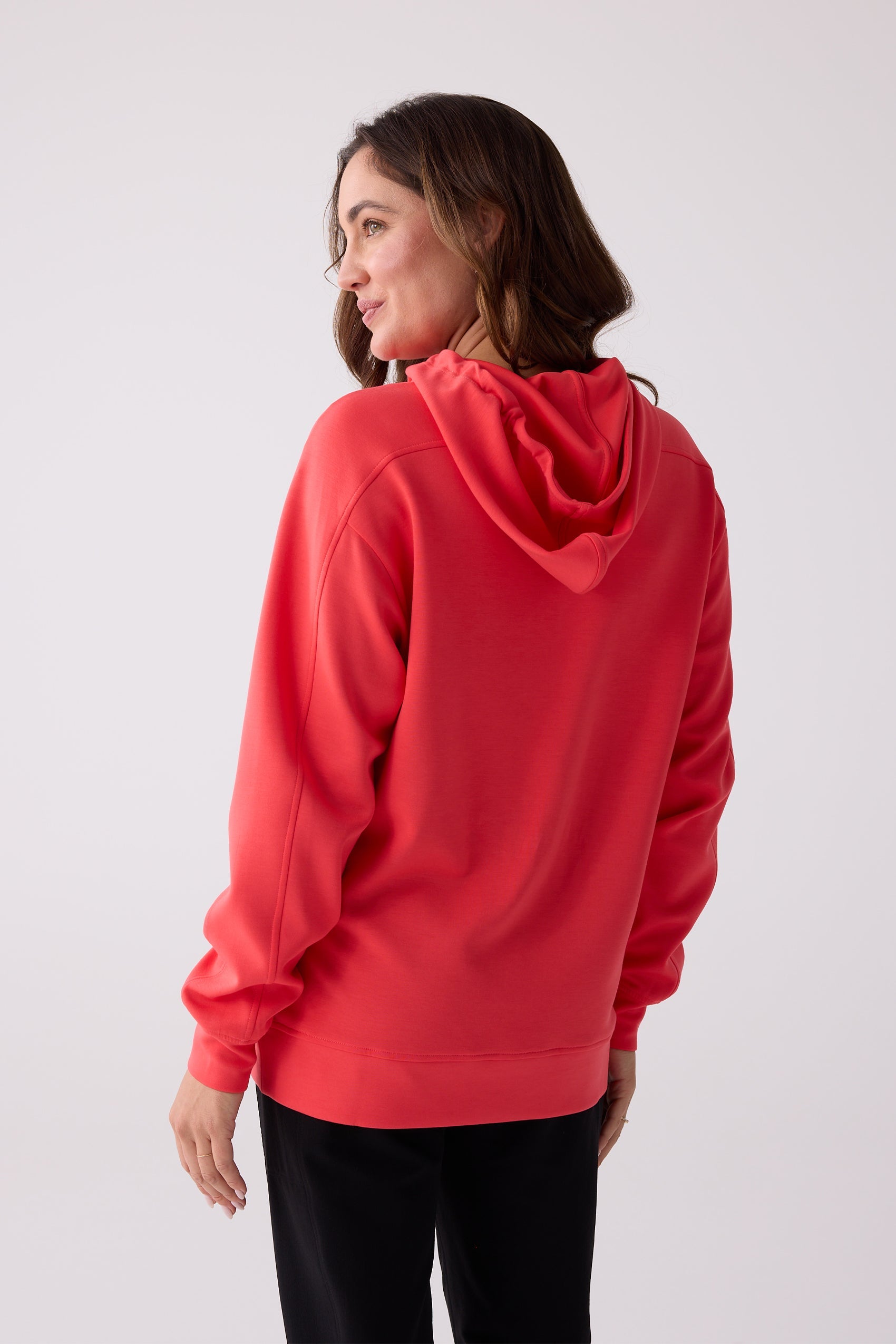 Red hooded sweatshirt by Centerline Athletics, back view on a woman, featuring a relaxed fit and ribbed hem.
