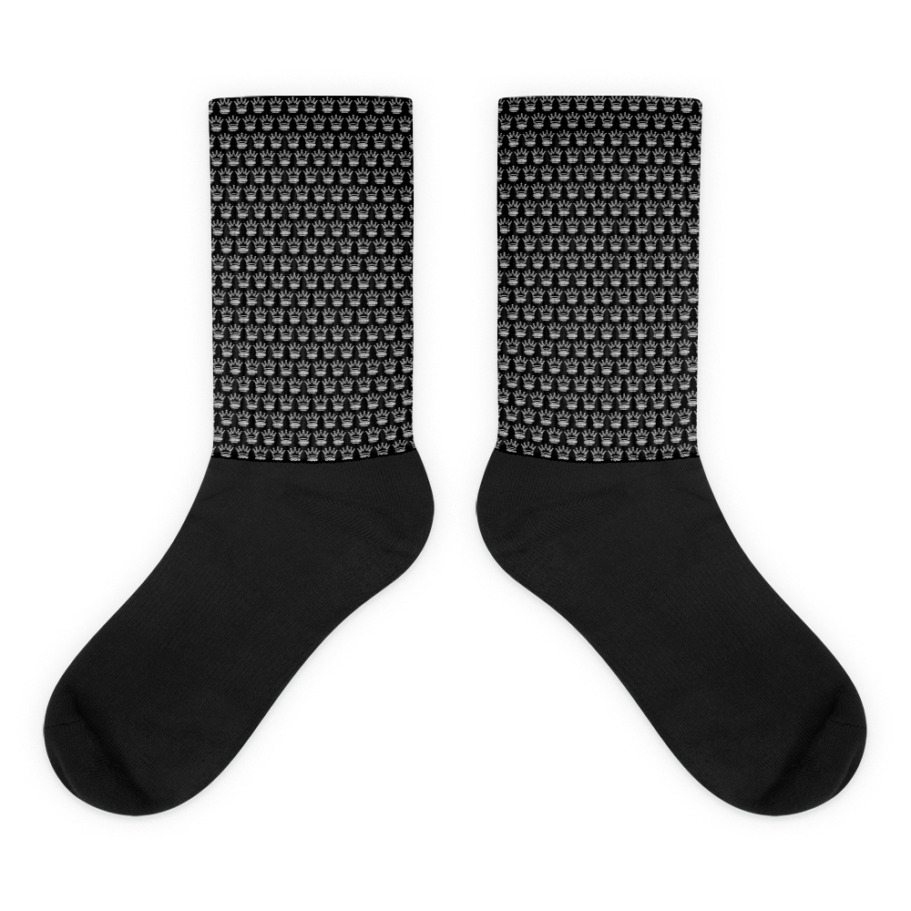 Pair of black socks with a crown pattern on the upper section.