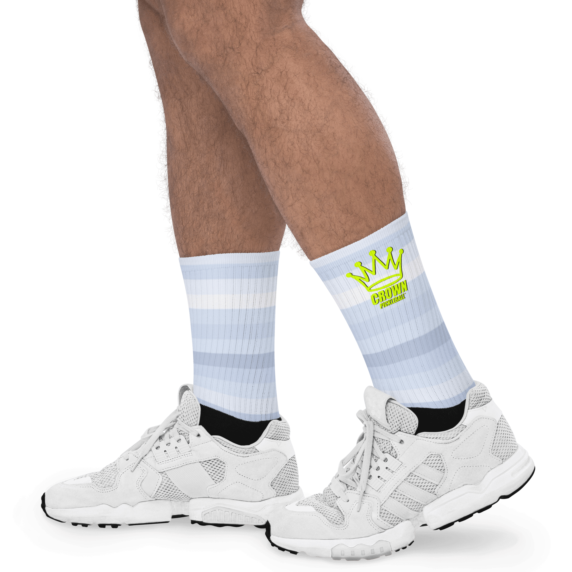 A person's legs wearing striped socks and white sneakers.