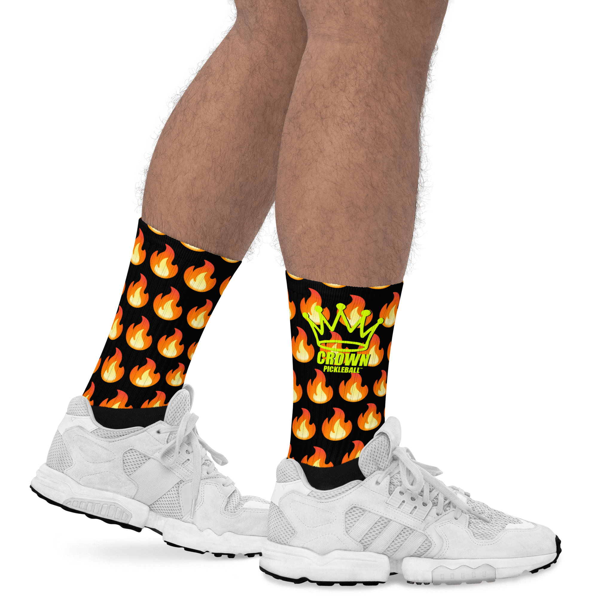 Legs wearing black socks with fire pattern and white sneakers.